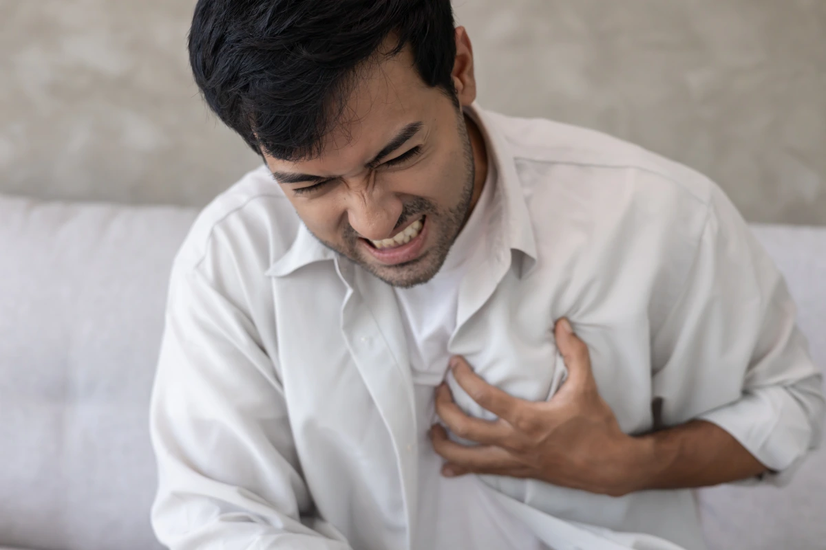Man experiencing chest pain as a warning sign of heart disease and ED.