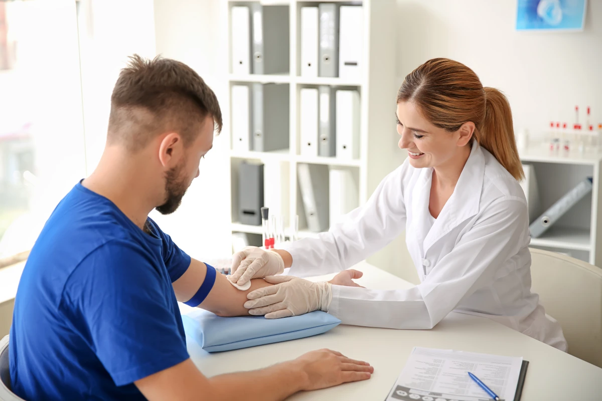 Doctor drawing blood from patient’s arm for medical testing and diagnosis.