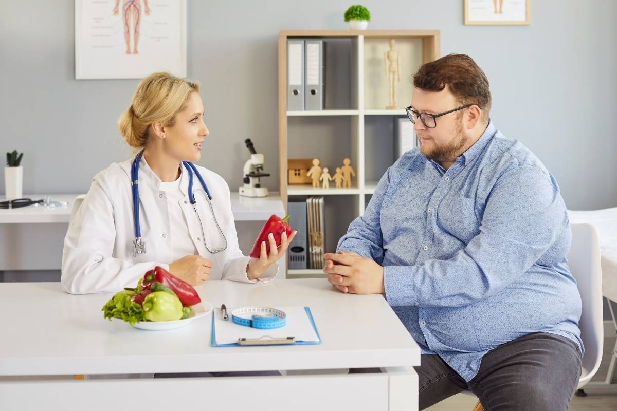 Doctor discussing obesity, erectile dysfunction, weight gain, hormone imbalance, and men’s metabolic health during a medical consultation.