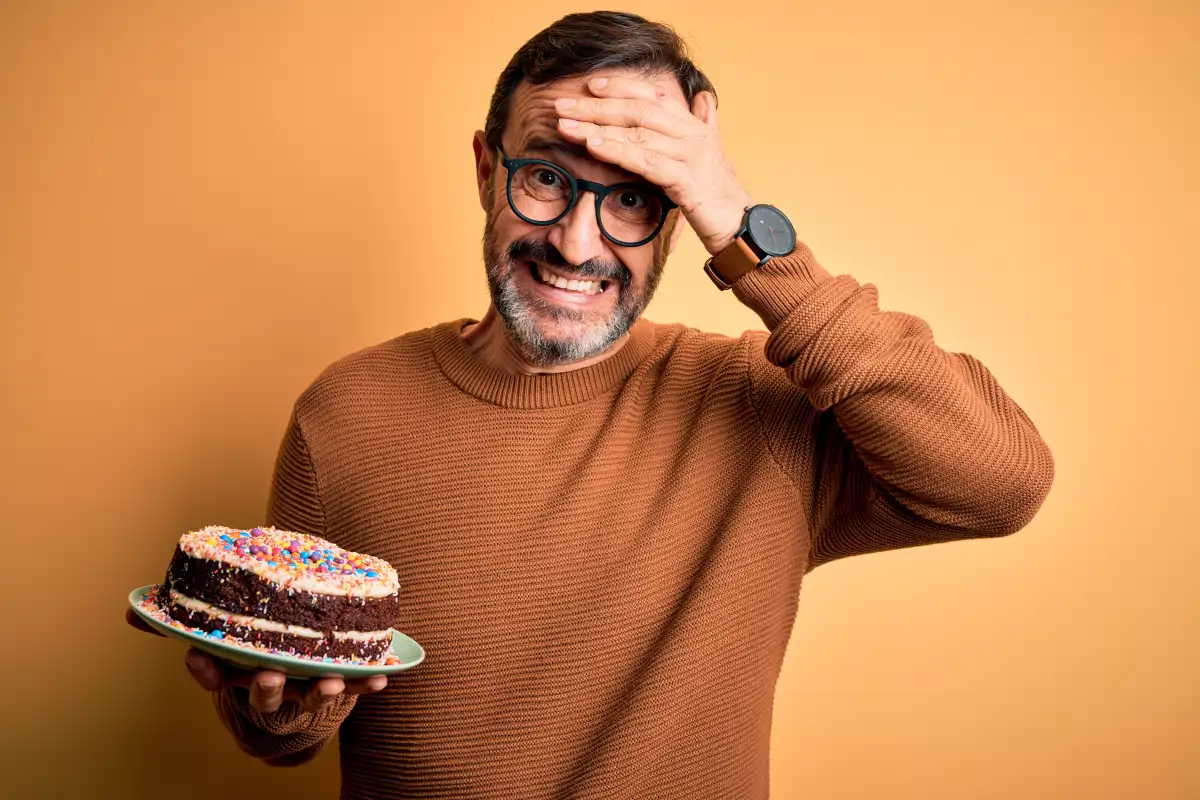 Middle-aged man holding cake while concerned about weight gain after 30 and slowing metabolism related to aging and hormone changes.