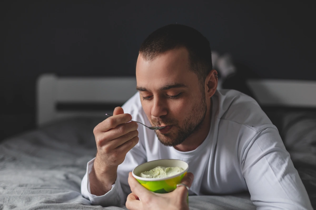 Man eating ice cream to illustrate insulin resistance, weight challenges, poor metabolism health, and belly fat in men.