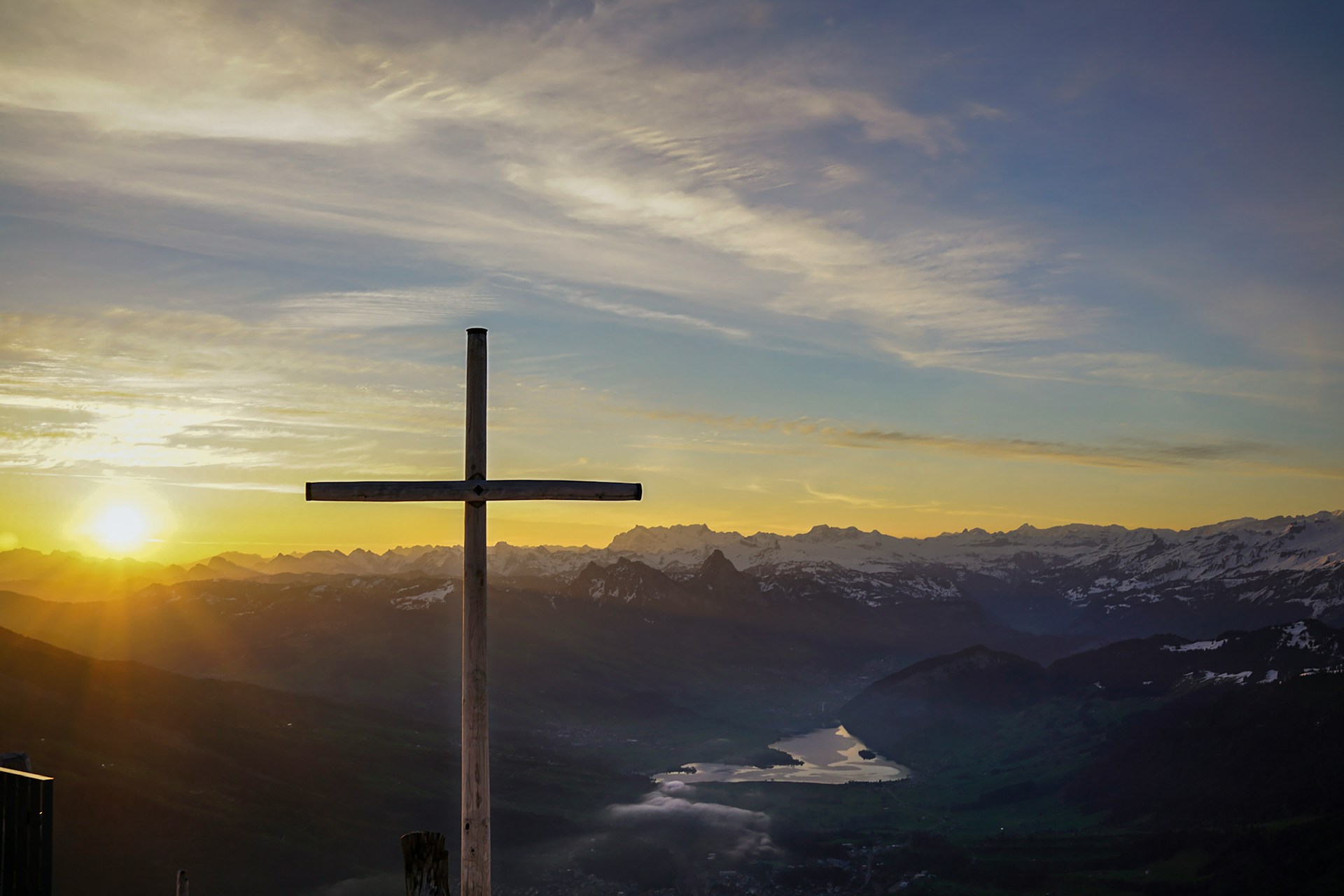A cross on a mountain at sunrise