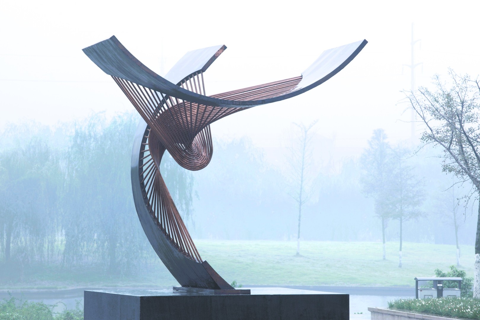 Tenth Gate Unlocked in a misty park, showing its interwoven bronze curves.