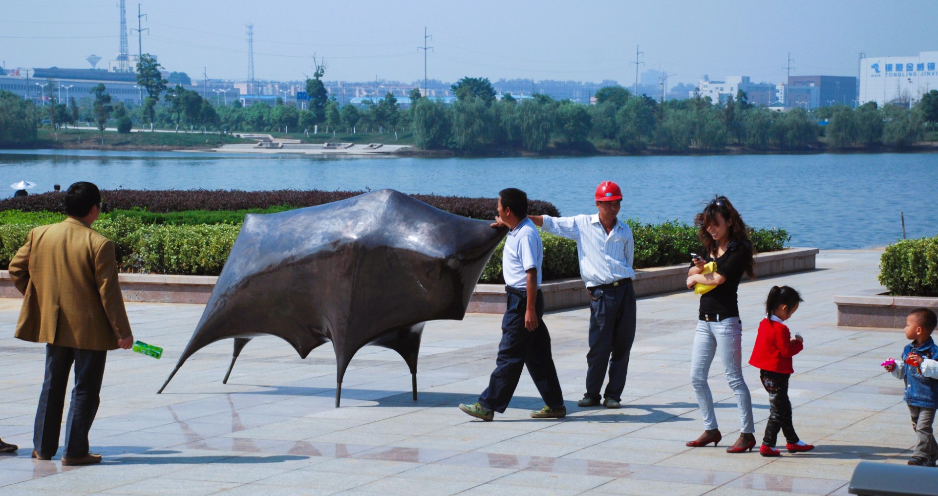 Visitors beside Bull in its lakeside park setting.