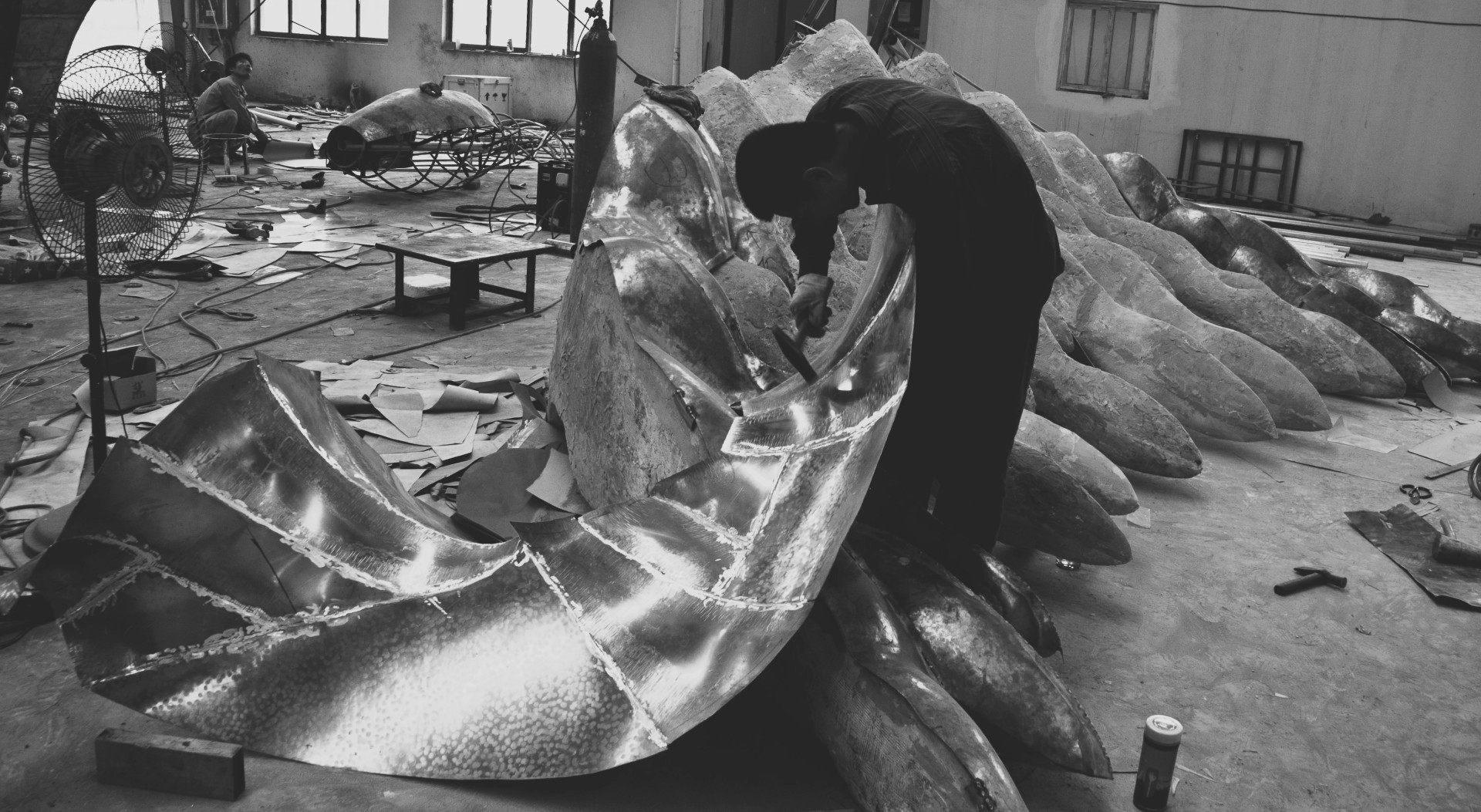 A craftsperson working on the curved surface of Moon Shadow-2.