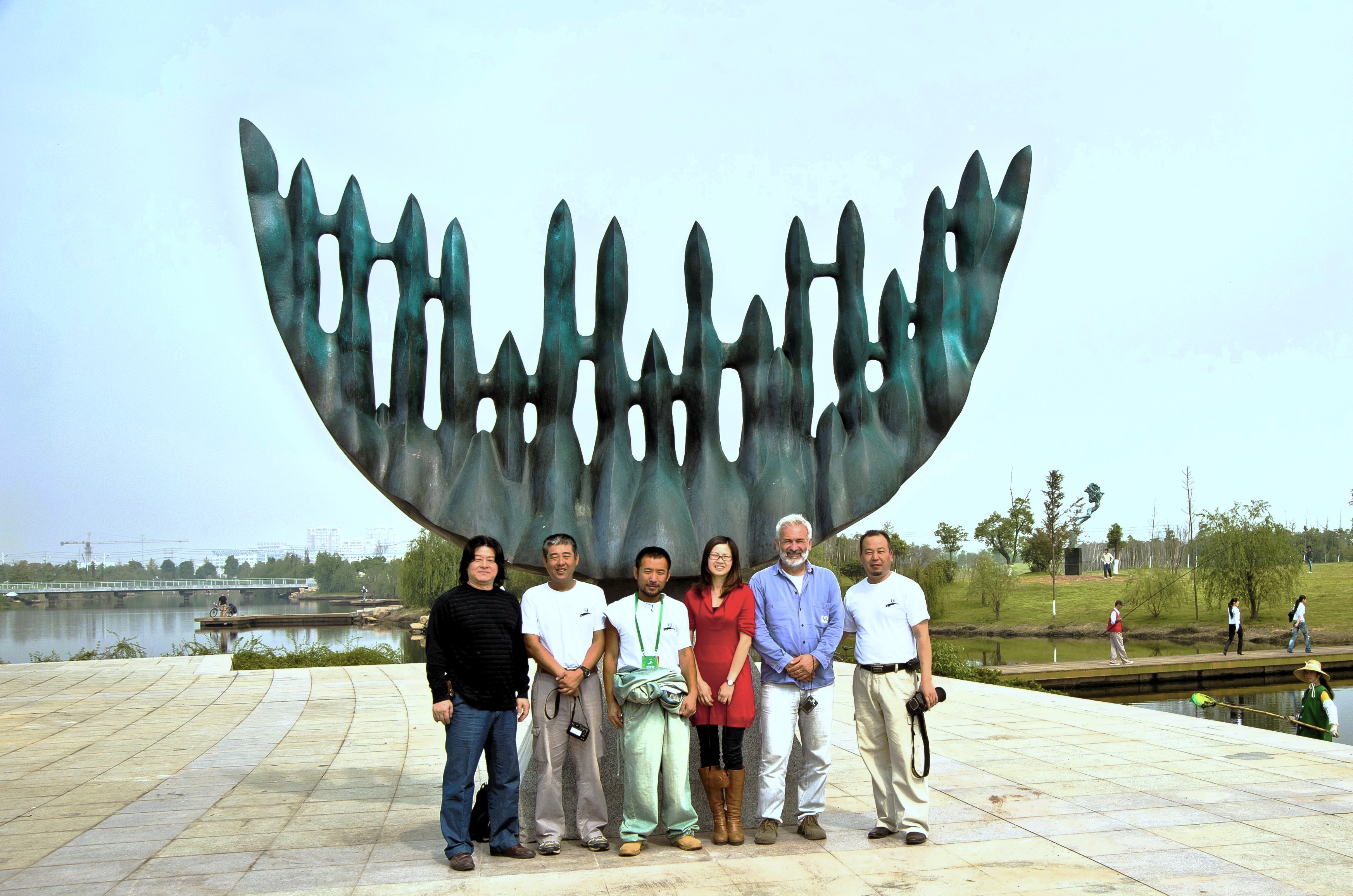 A group standing beside Moon Shadow-2 in its lakeside setting.