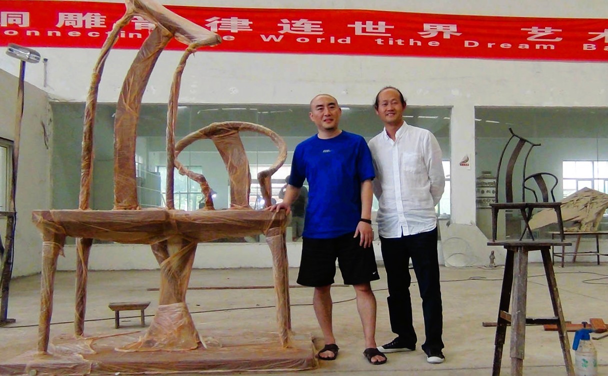 Two people beside Whisper in the workshop.