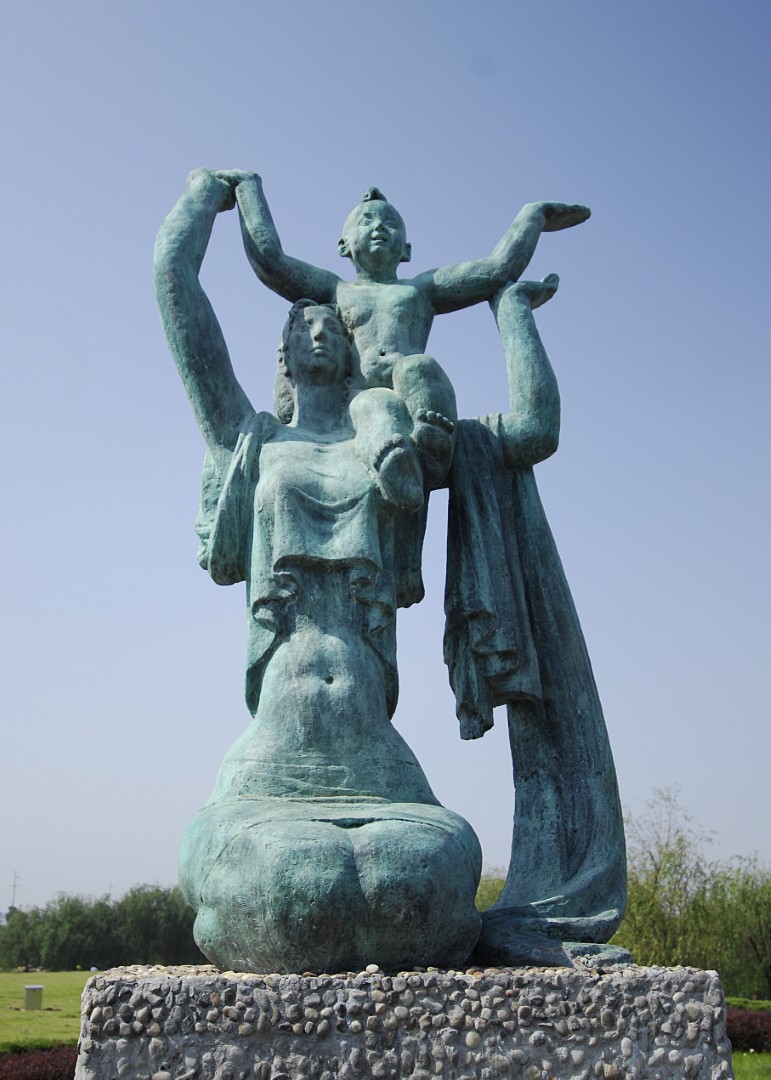 The Rising Sun, bronze sculpture of a mother lifting a child