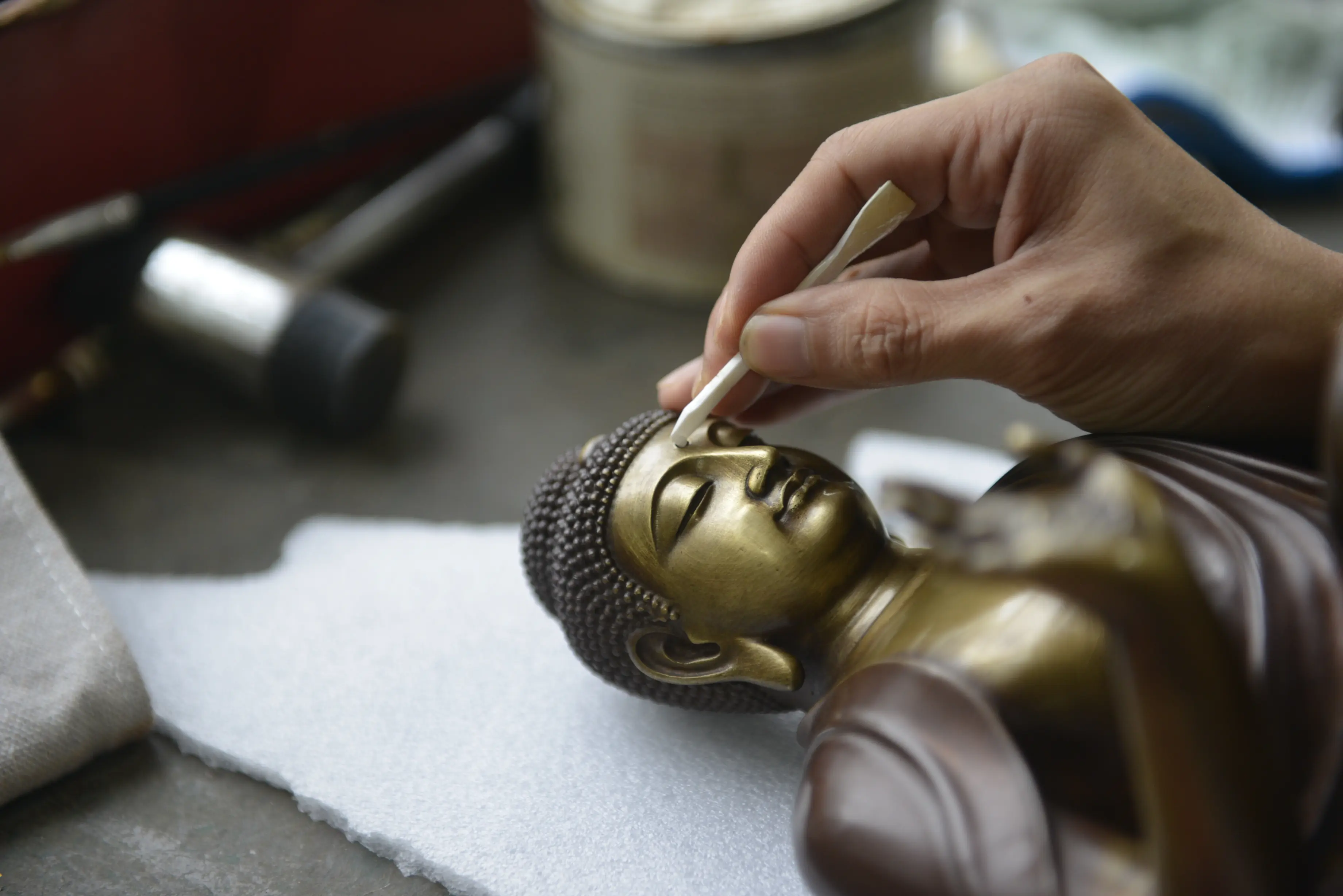 Shakyamuni Buddha — Hand finishing the facial details