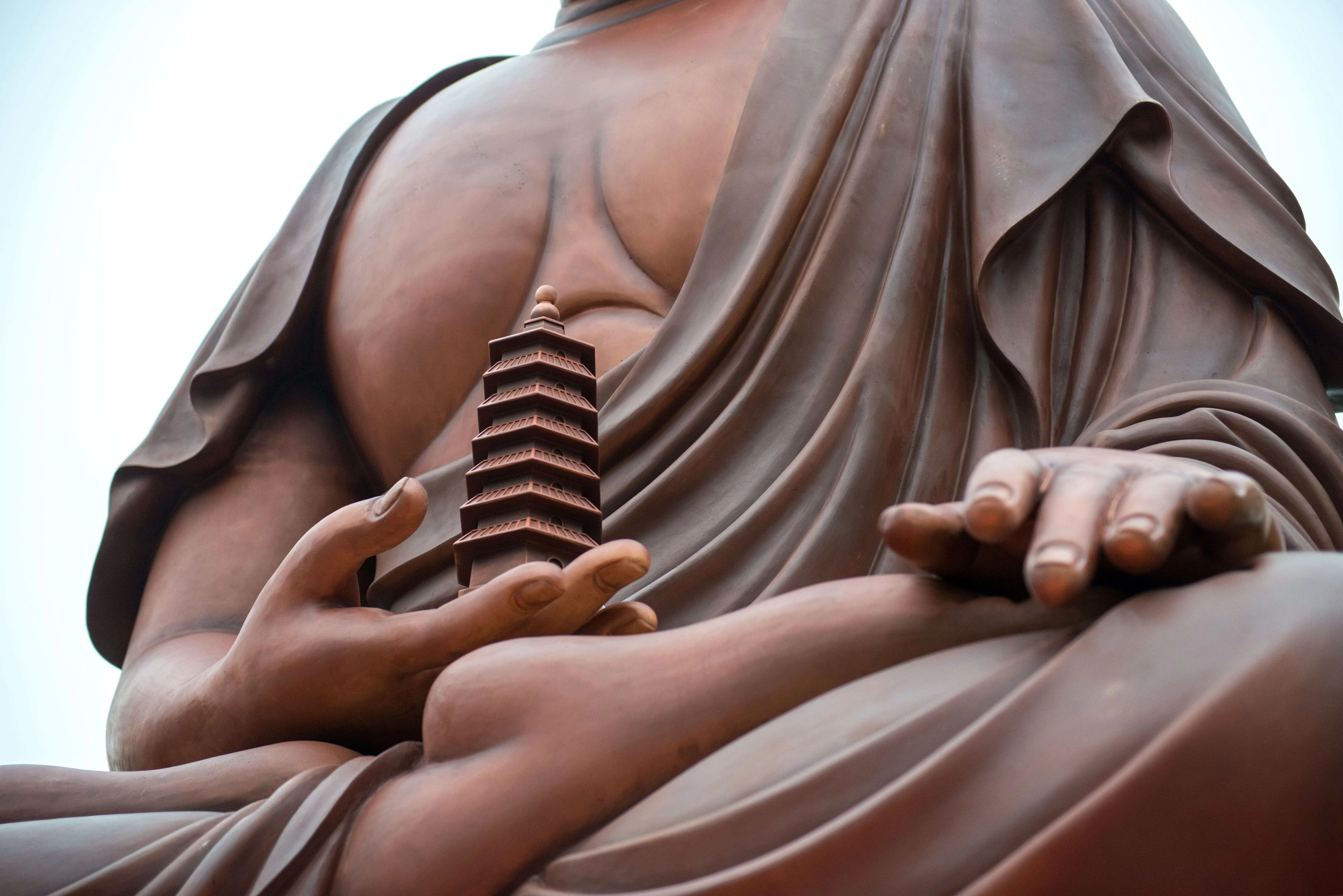 Buddhas of the Three Times at Xifeng Chan Temple — Hands, robes and pagoda detail