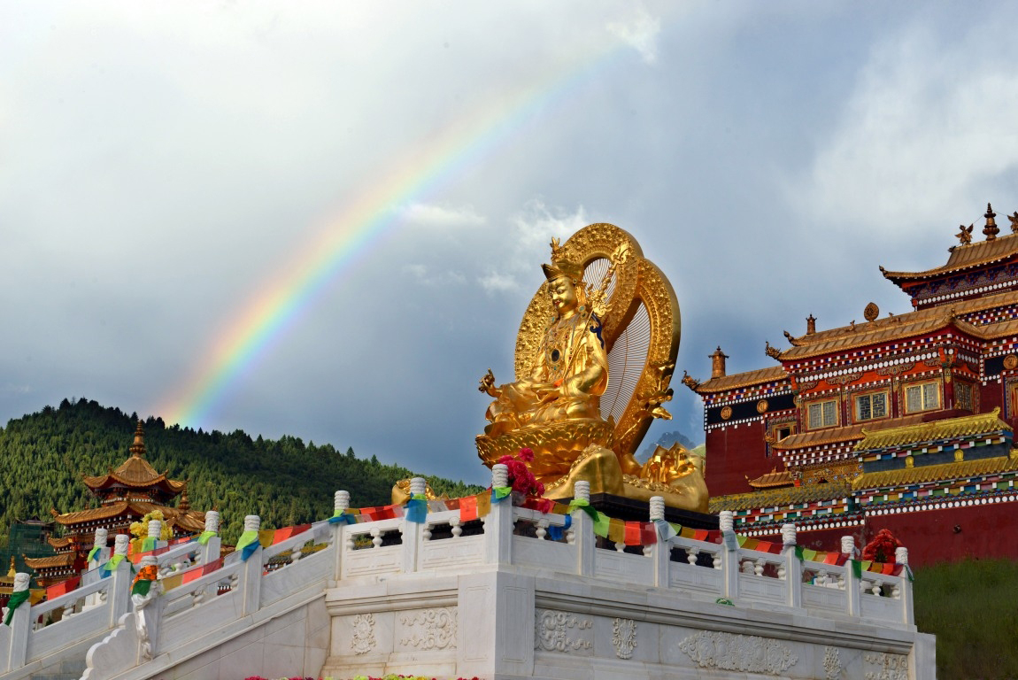 Guru Rinpoche Statue — An outdoor view beneath a rainbow