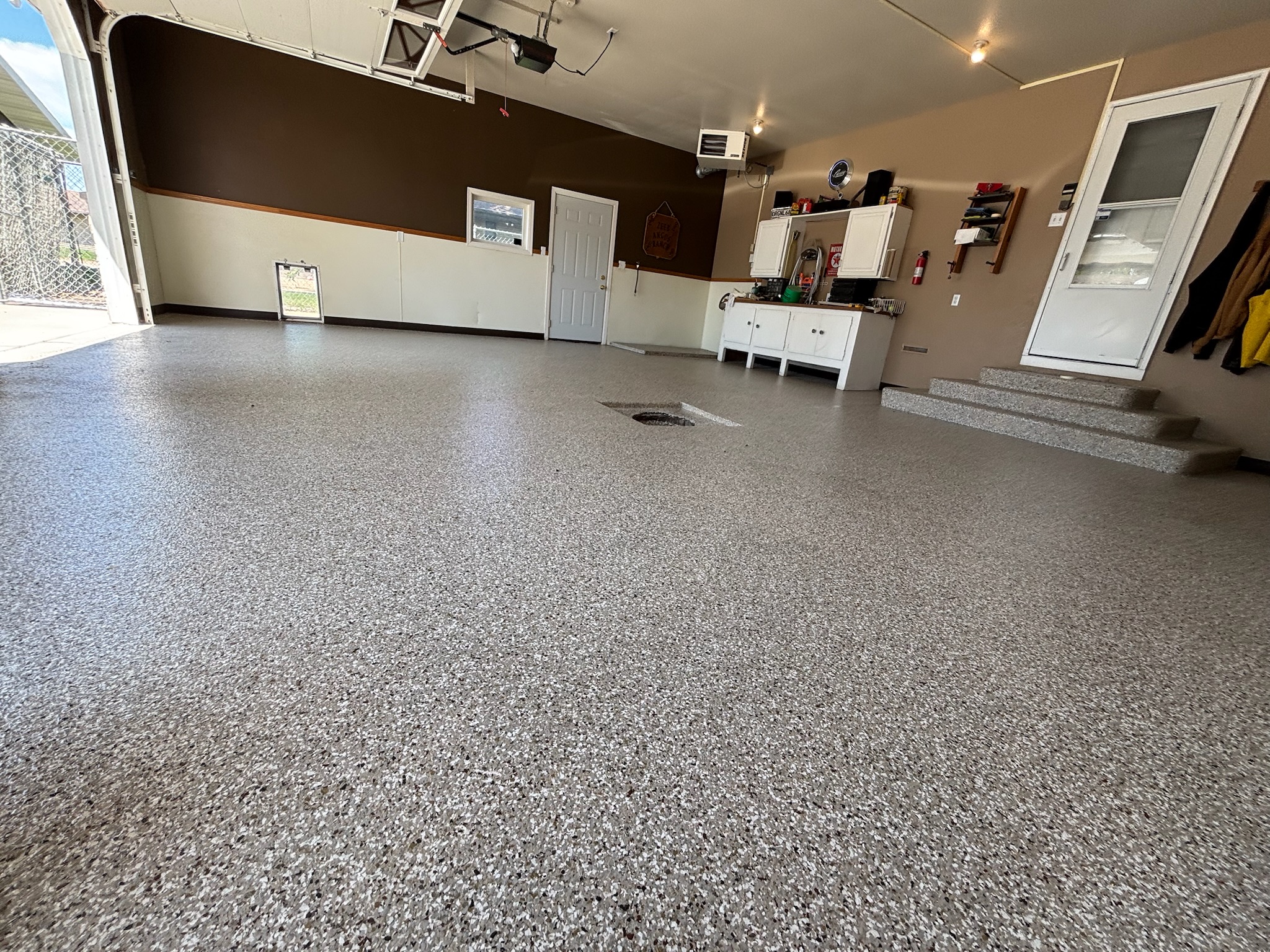 Armour floors finished installation close up of a gray epoxy fully broadcast flake garage floor in Bismarck, ND