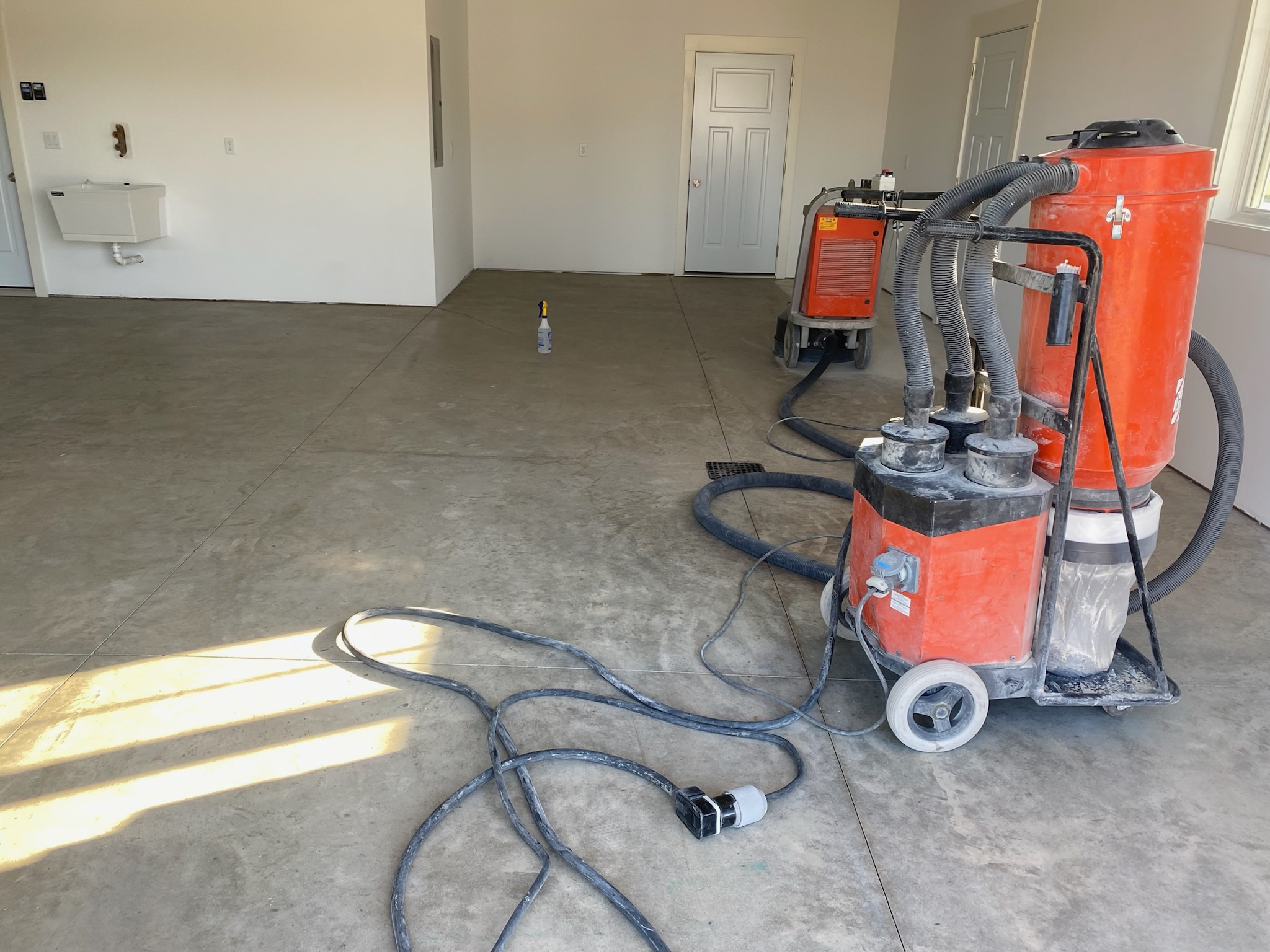 Armour floors concrete diamond grinder and vacuum setup in unfinished garage in Mandan ND