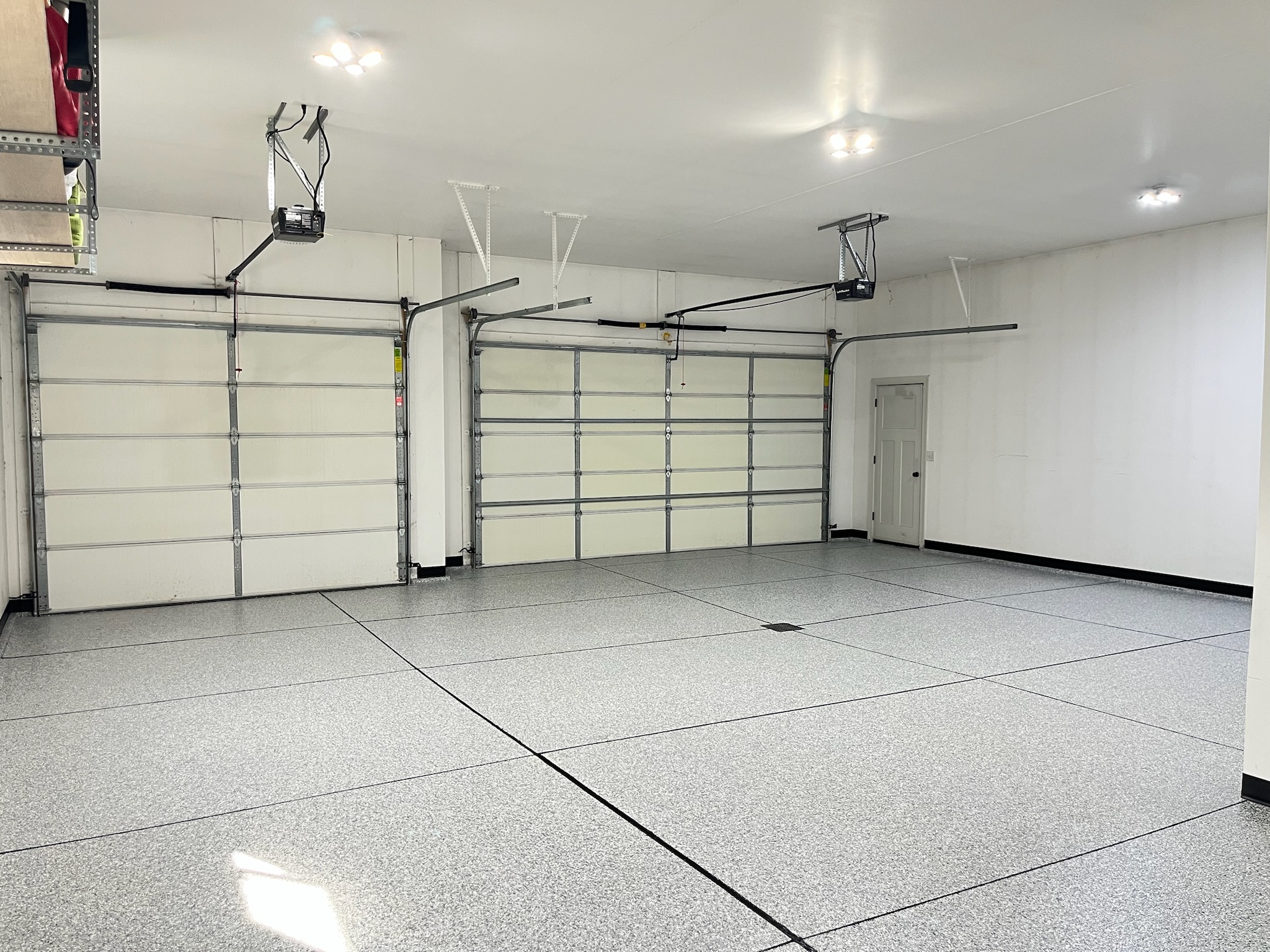 Empty clean three stall garage interior with professionally installed epoxy floor in Bismarck ND.