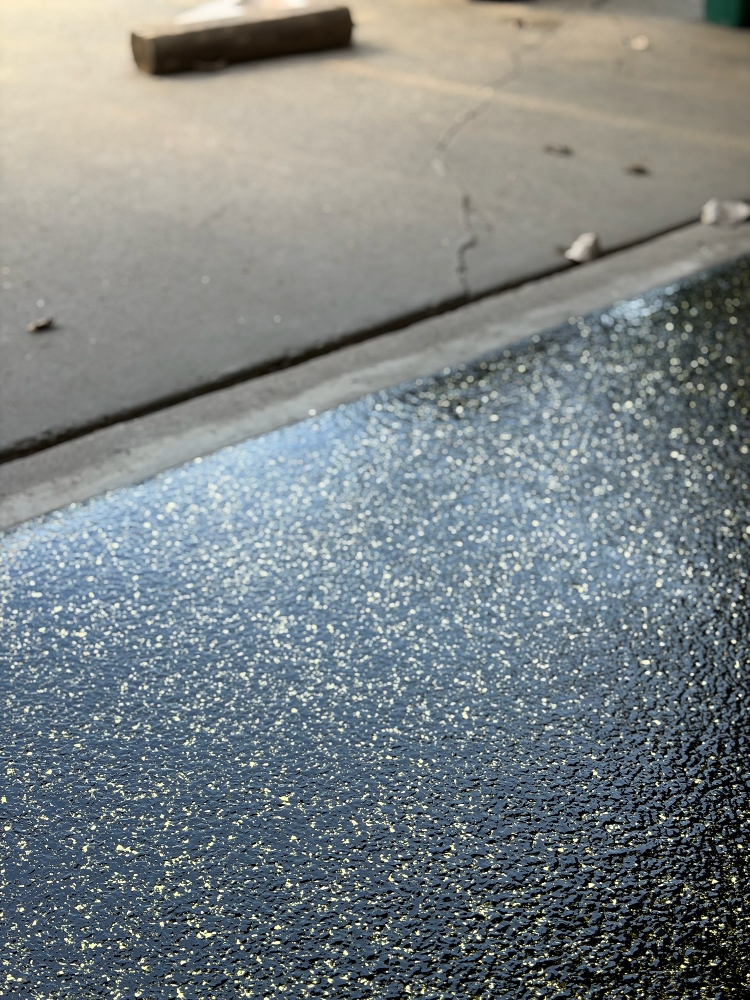 Close-up of custom epoxy floor coating gold and black, professionally finished.