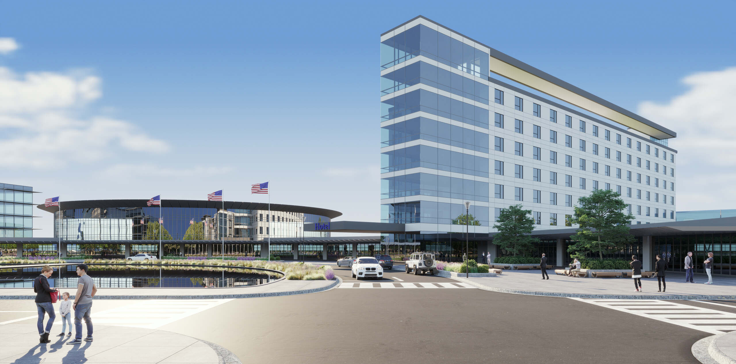 Modern hotel and office buildings with people and cars in a landscaped urban plaza area.