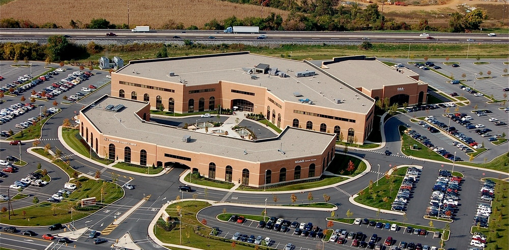 Aerial view of a large U-shaped medical center surrounded by parking lots and roads.