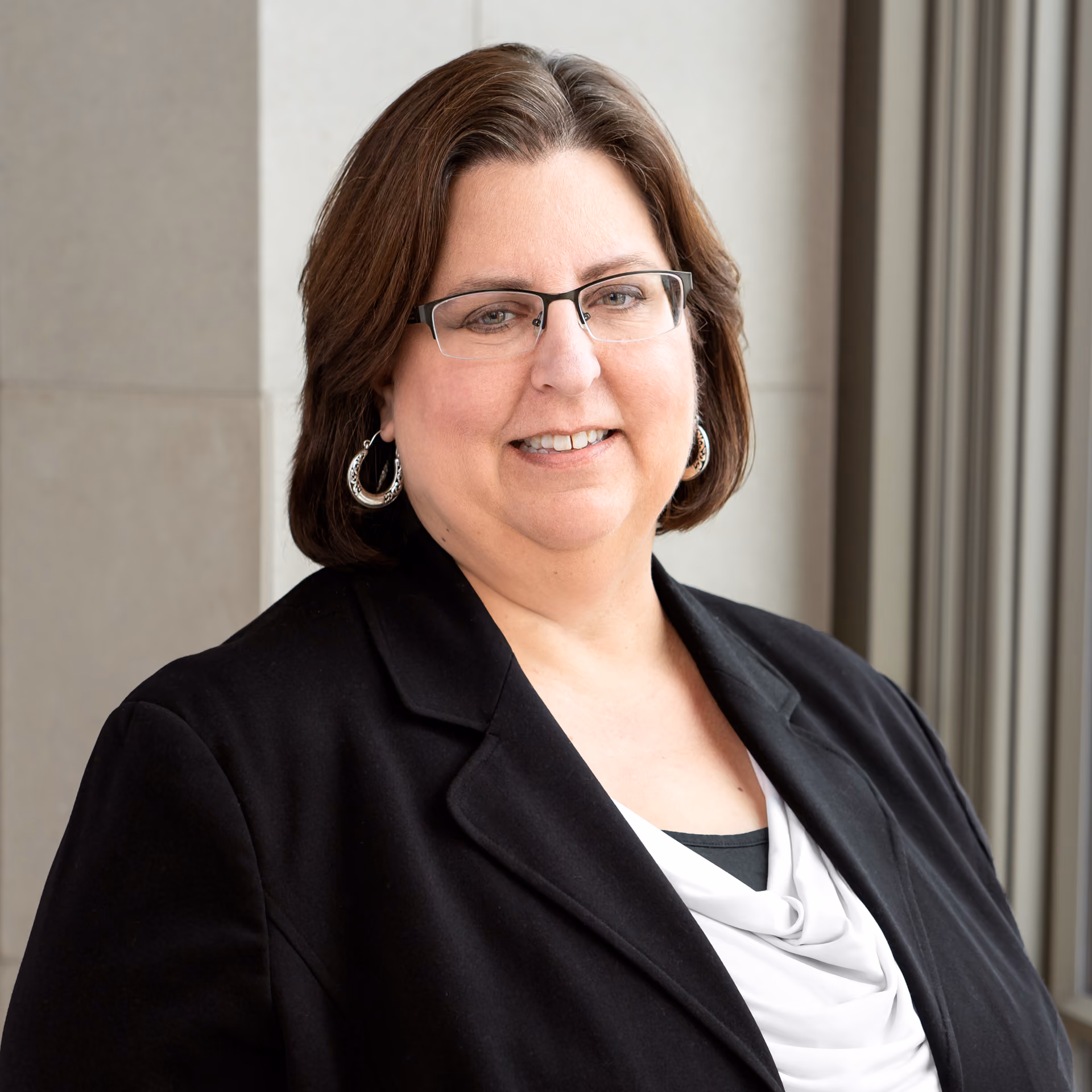 Kelly Peters, Assistant Director Due Diligence, Hammes Realty Services, with short brown hair wearing glasses, silver earrings, and a black blazer over white top.