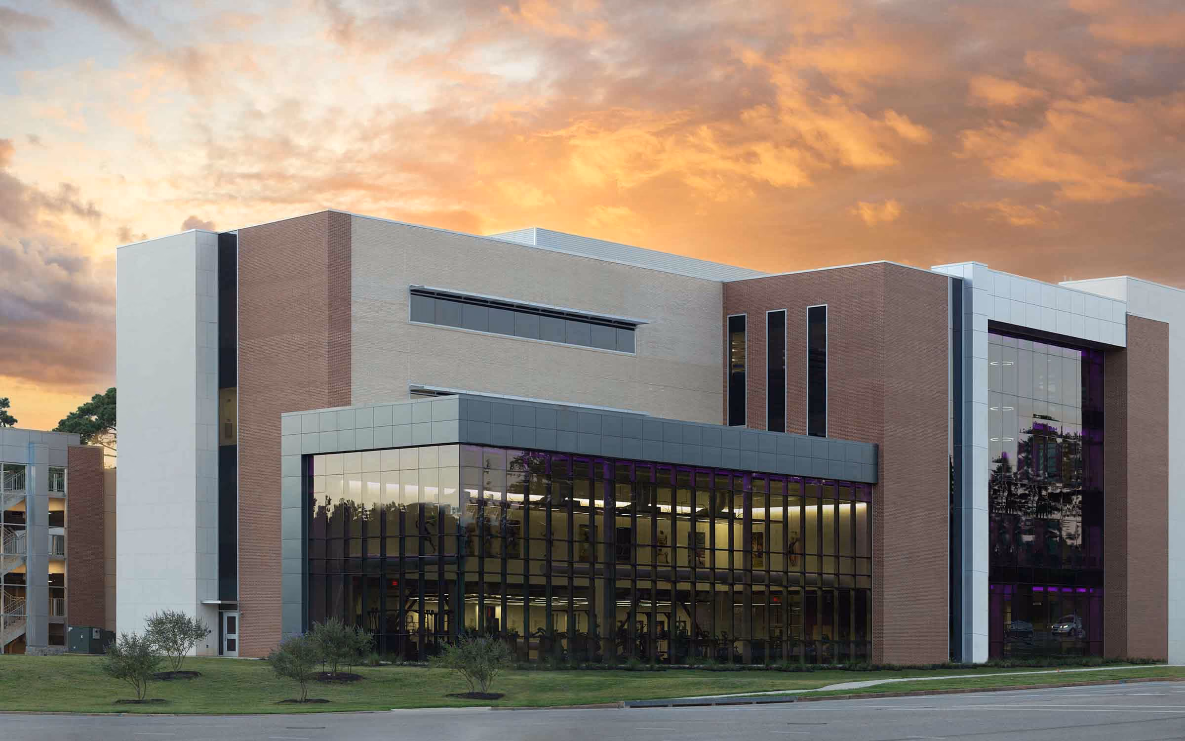 Christus Orthopedic modern medical building with large glass windows and illuminated interior at sunset.