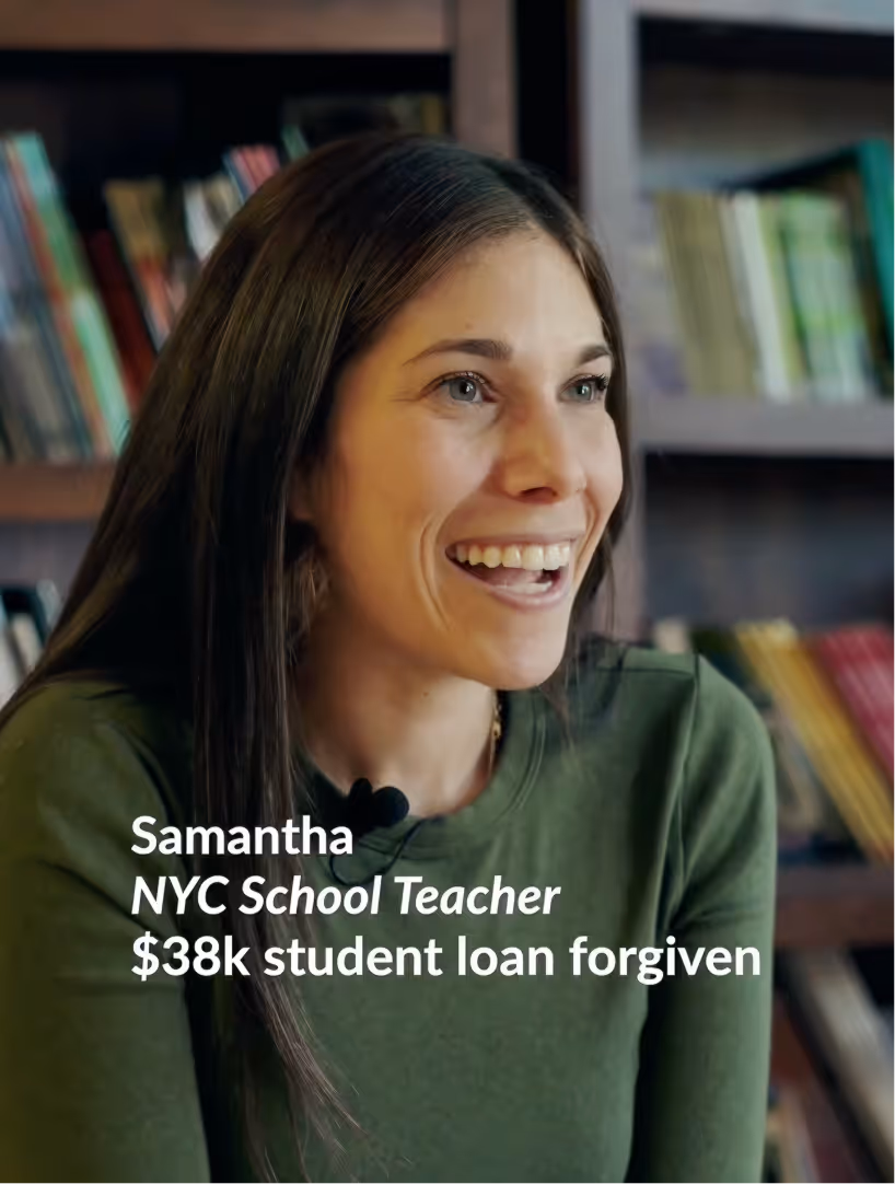 Smiling woman with long brown hair in a green top, bookshelves in background.