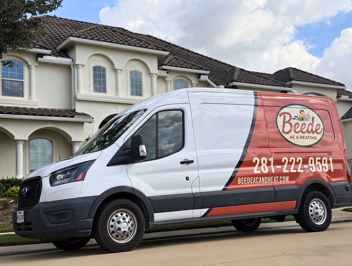 White and red service van parked in front of a large beige house with columns, displaying Beede AC & Heating logo, phone number 281-222-9591, and website beedeacandheat.com.