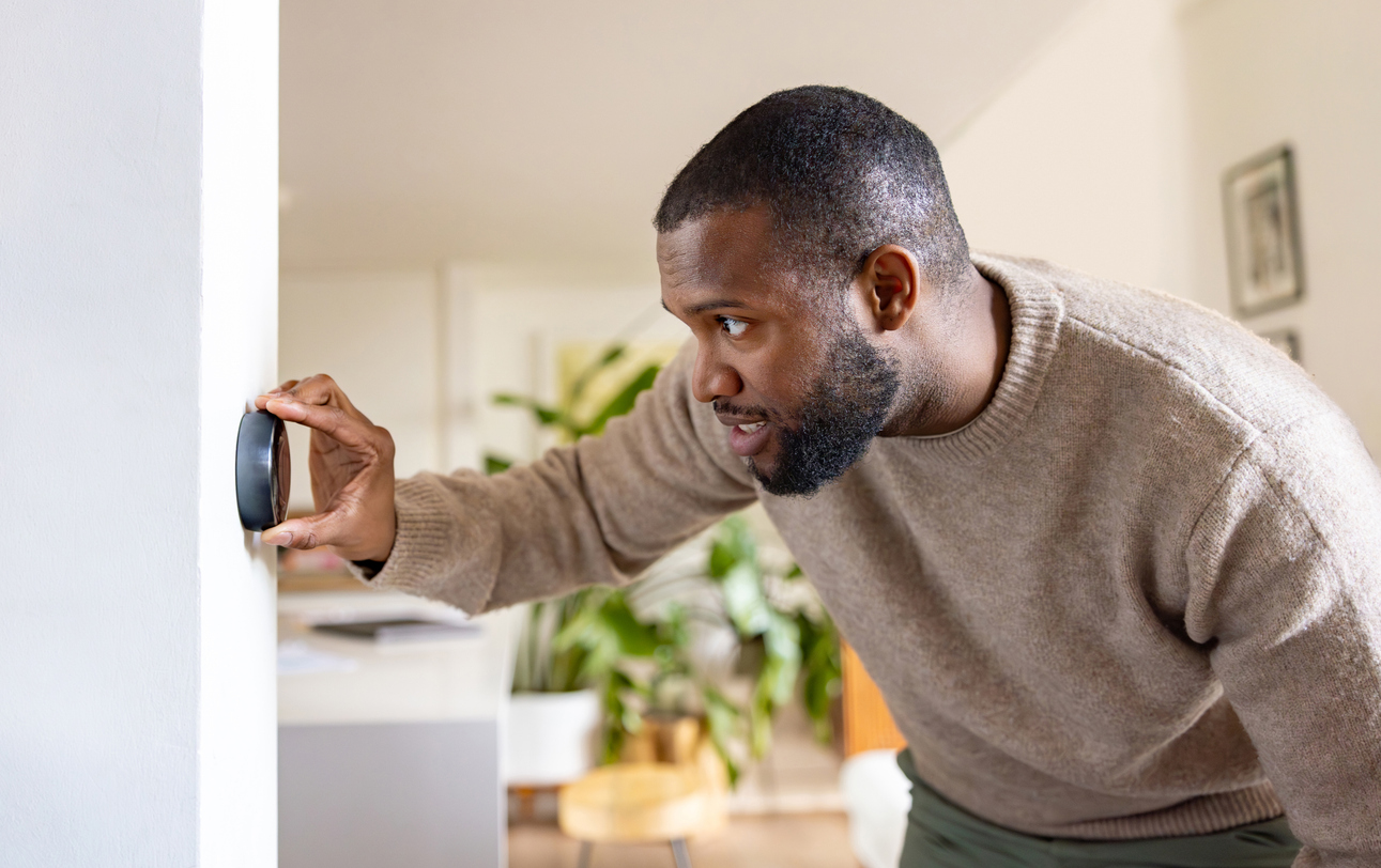 man changing thermostat