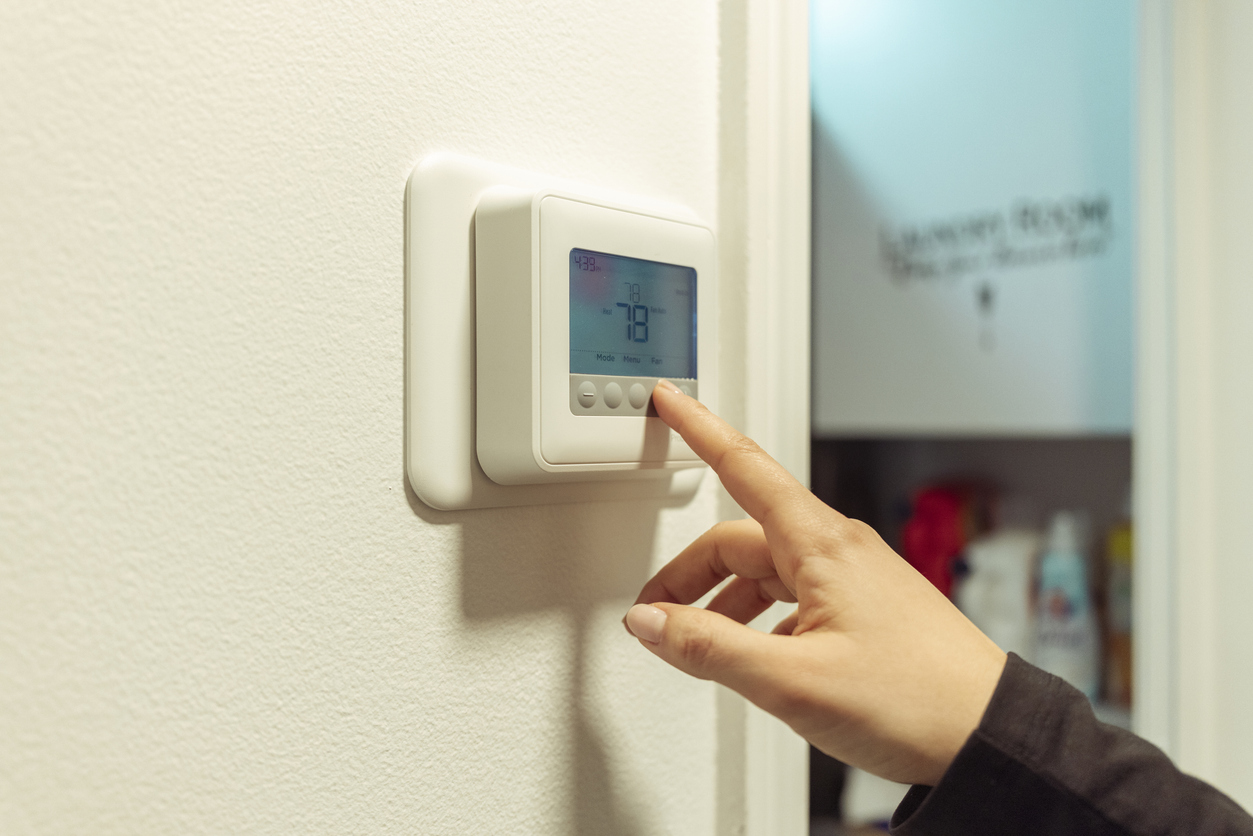 man changing thermostat