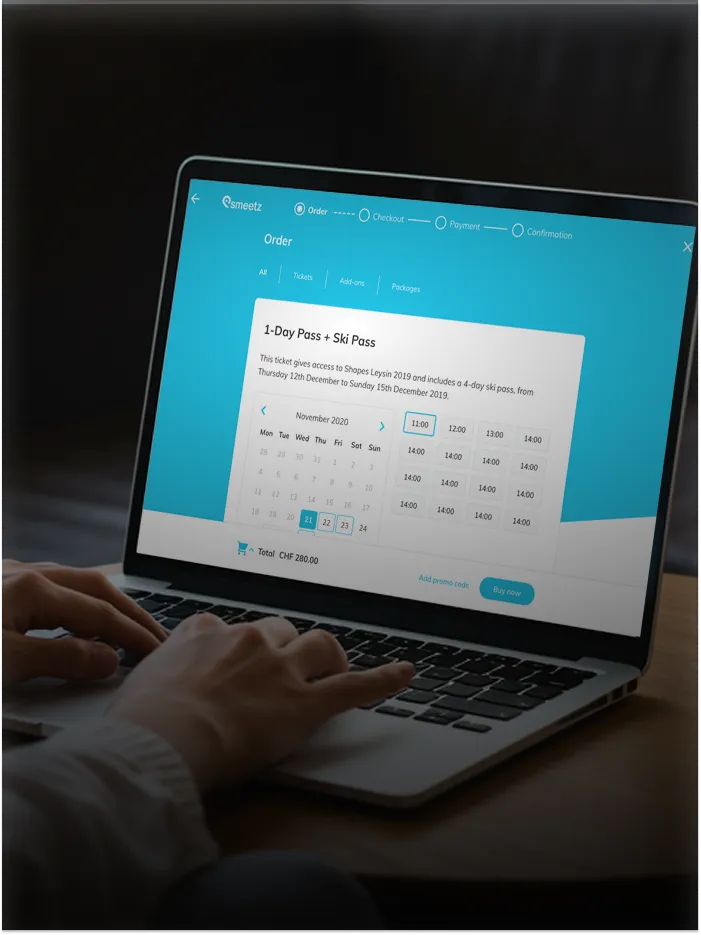 Person using laptop to book 1-Day Pass + Ski Pass on a blue ticketing webpage.