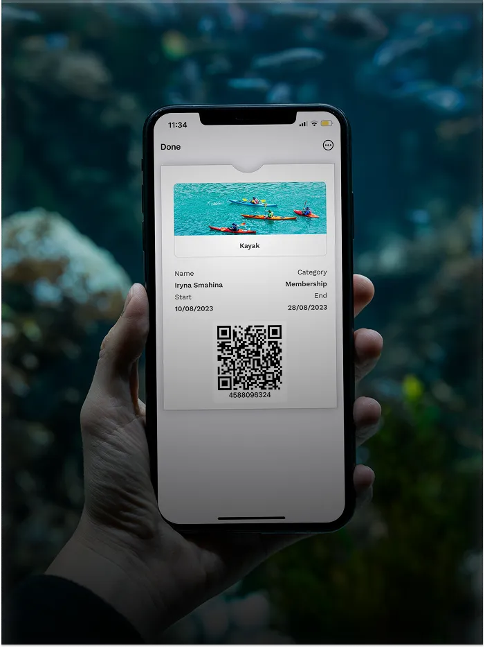 Hand holding phone showing digital kayak membership with name, dates, QR code, and kayak image.