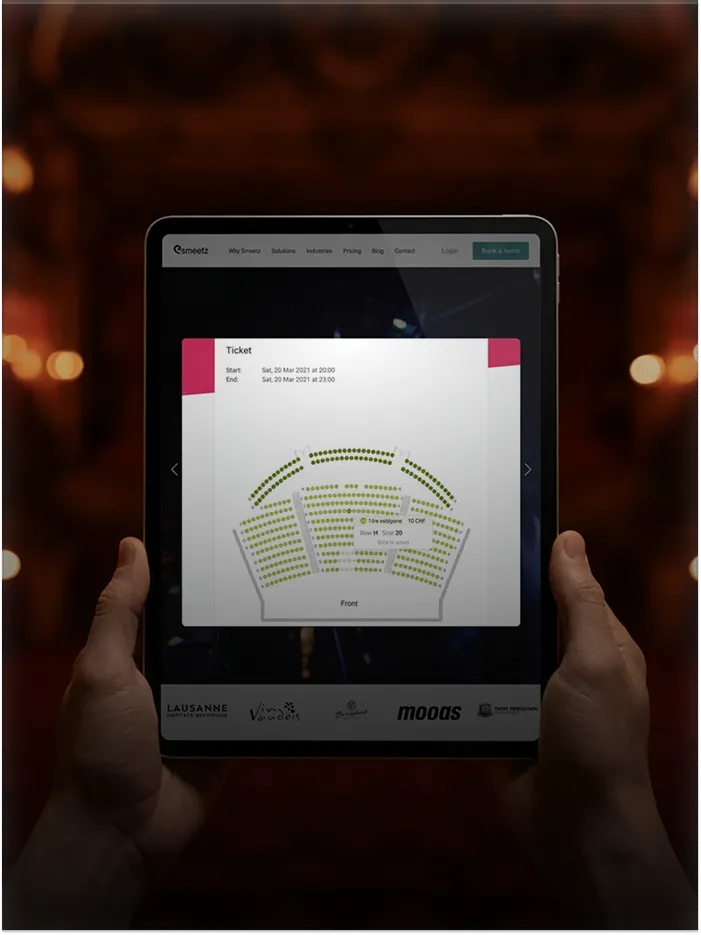 Person holding a tablet displaying a digital seating chart with ticket details for a 2021 event.