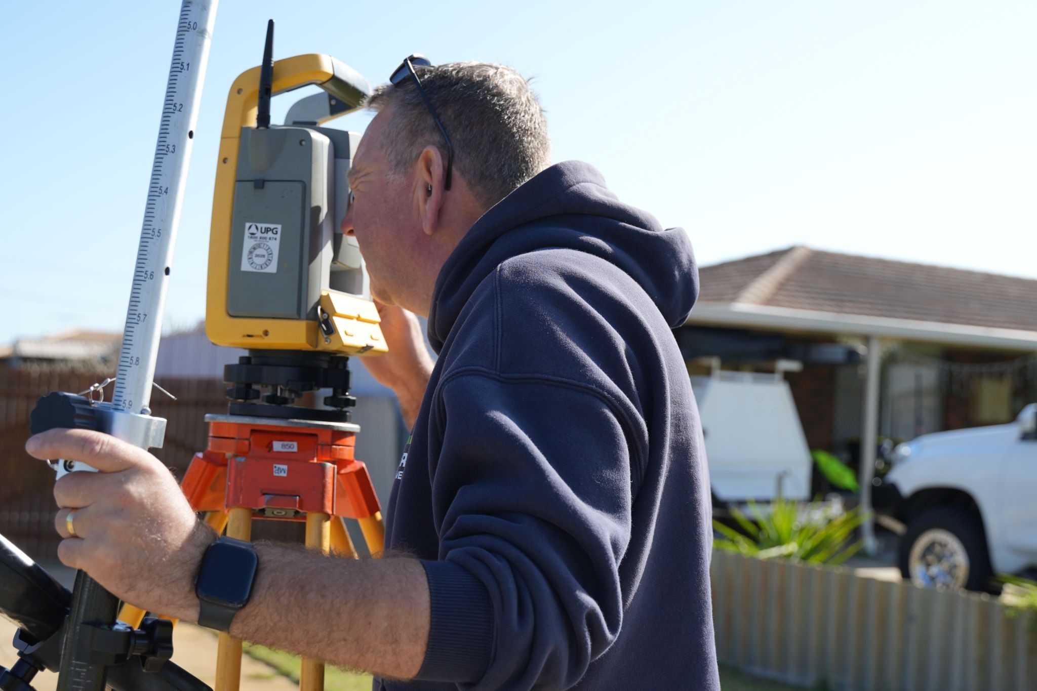 An image of a surveyor measuring the legal boundary of a property.