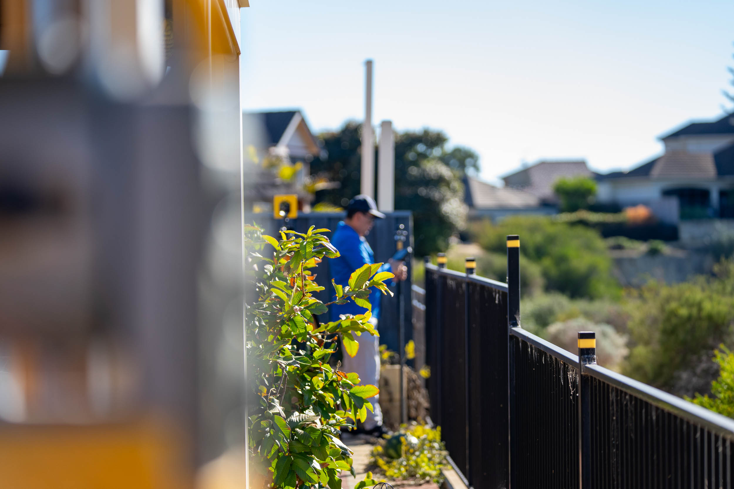 An image of a surveyor in front of a fence for an article about land subdivision challenges in Perth.