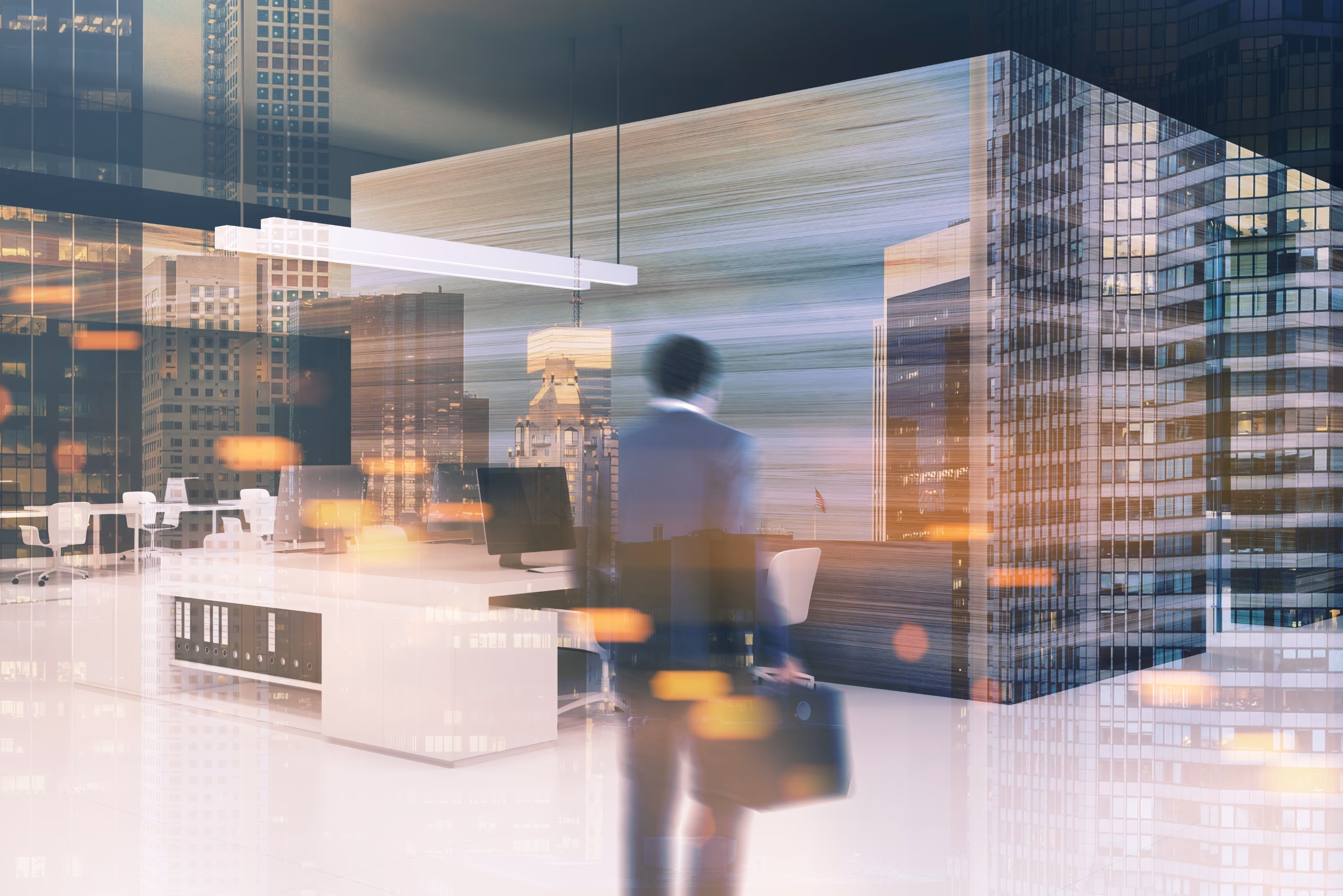 Blurred figure of a person holding a briefcase standing in a modern office with desks, chairs, and computers, overlaid with reflections of tall city buildings at dusk.