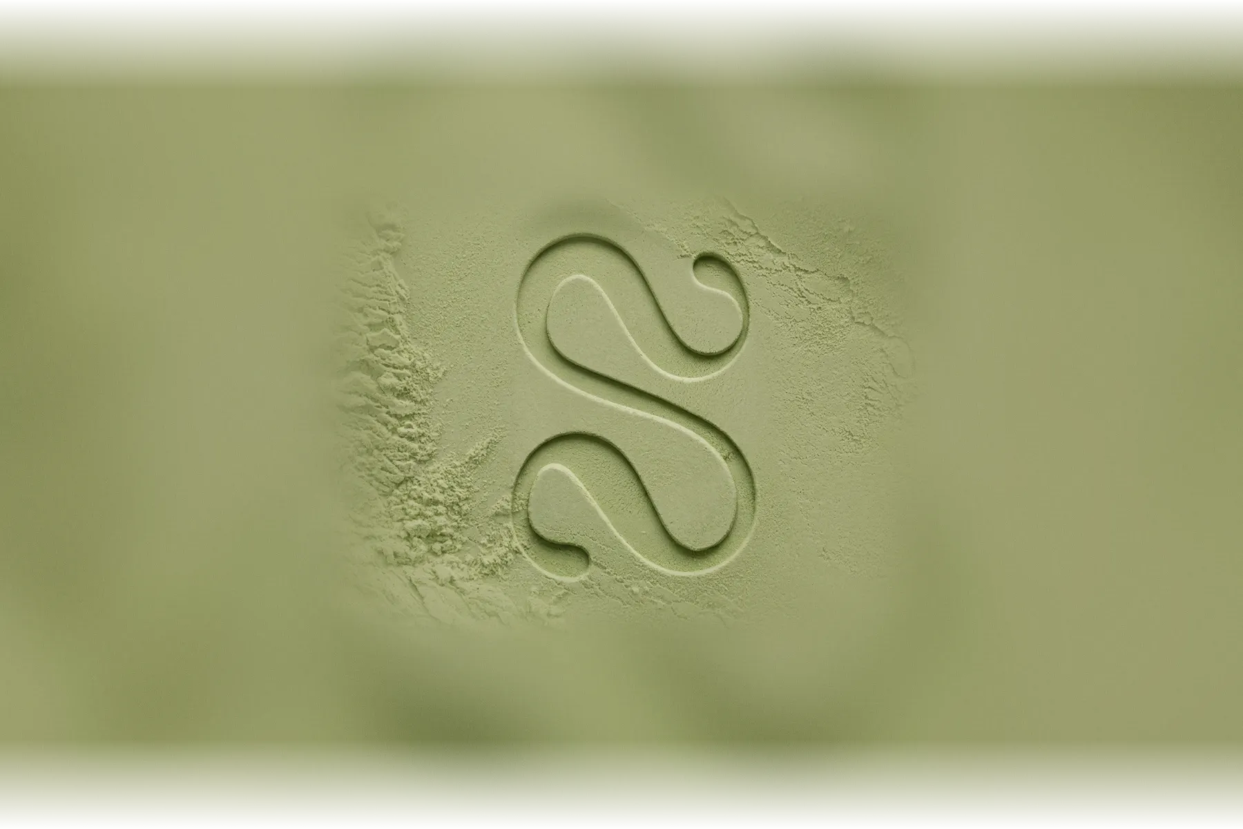The Solstice monogram pressed into pale sage clay