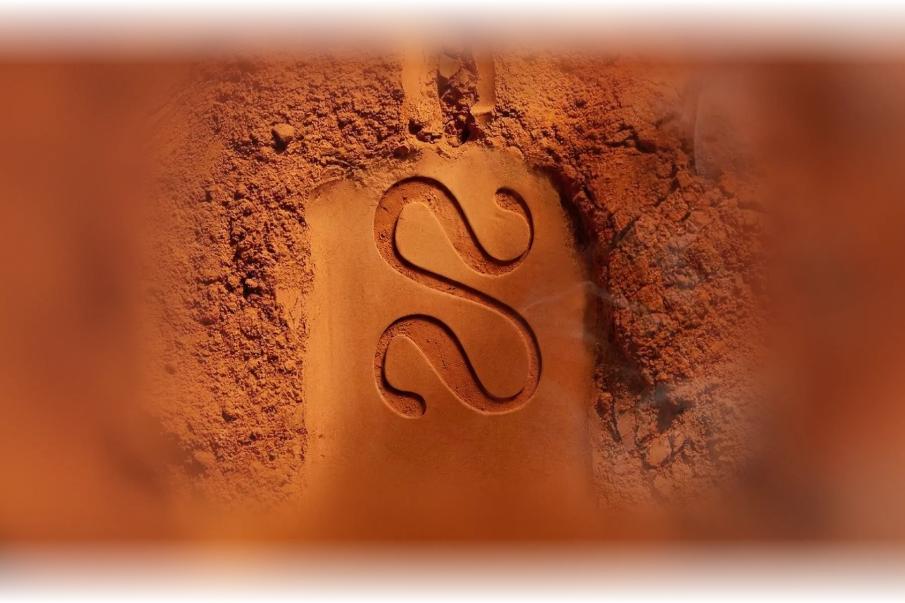 The Solstice monogram cut into red terracotta earth