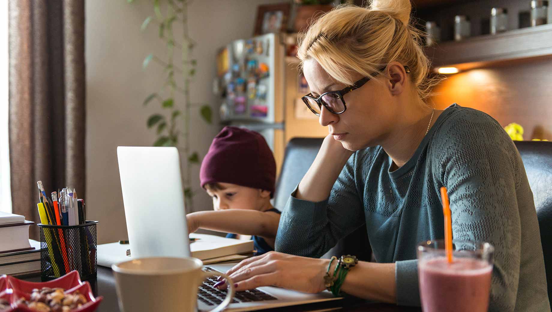 Working mother balancing a professional conversation with family responsibilities