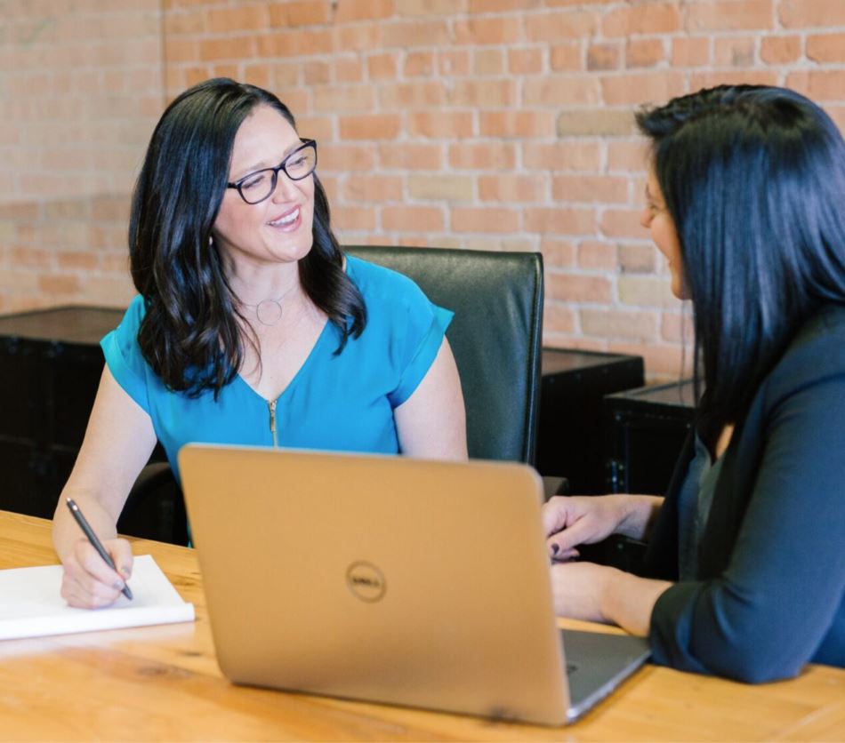 Manager and employee having a constructive feedback conversation at a laptop