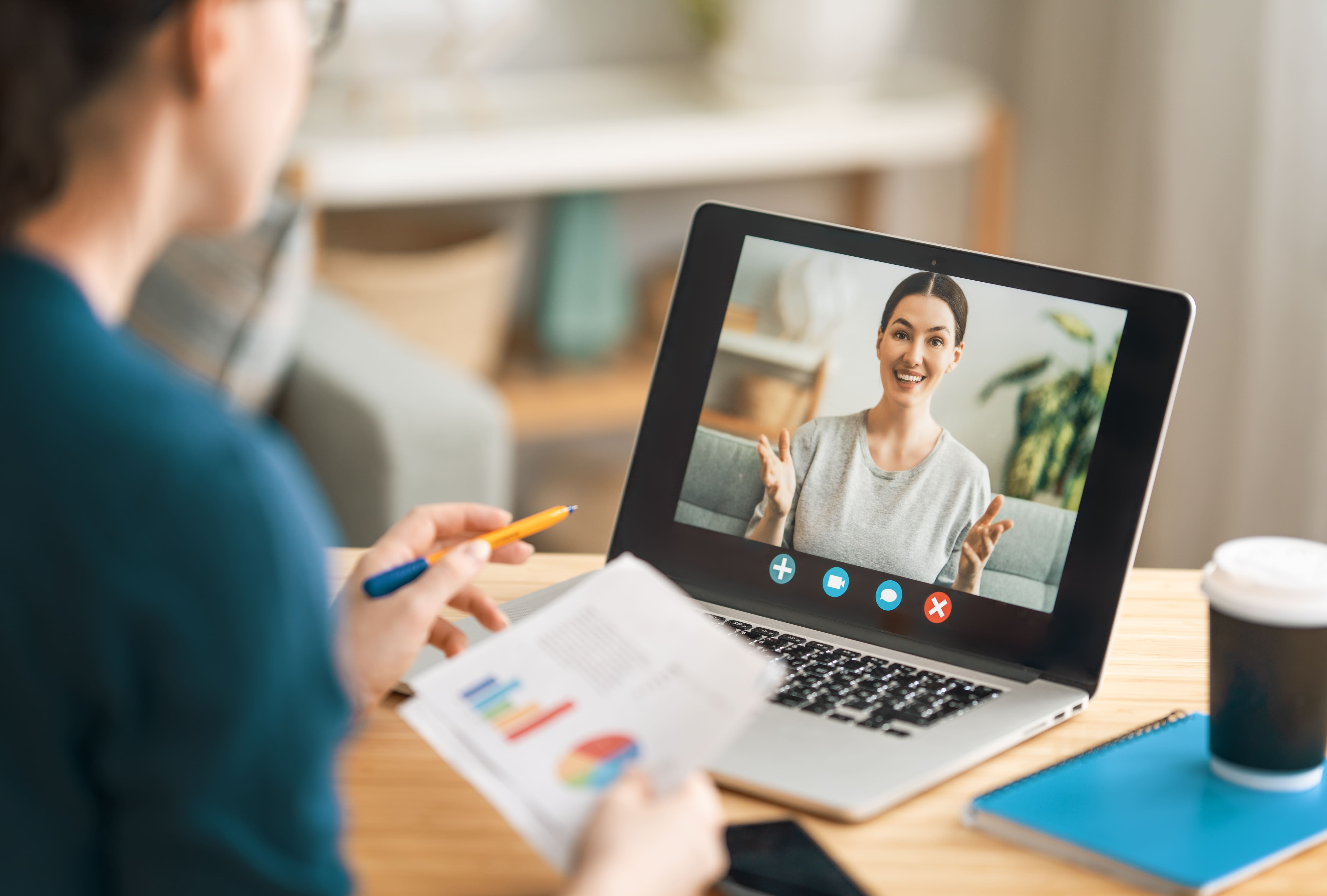 Manager reviewing documents during a one-to-one video meeting with a remote employee