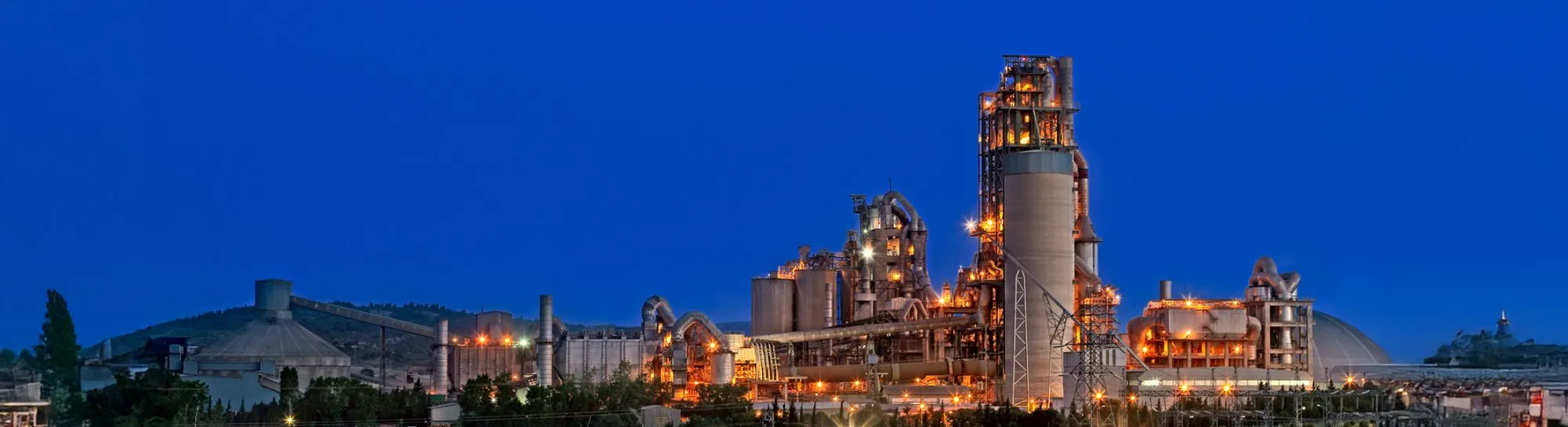 Gece ışıklarıyla aydınlanan Akçansa çimento fabrikası tesisinin panoramik görünümü