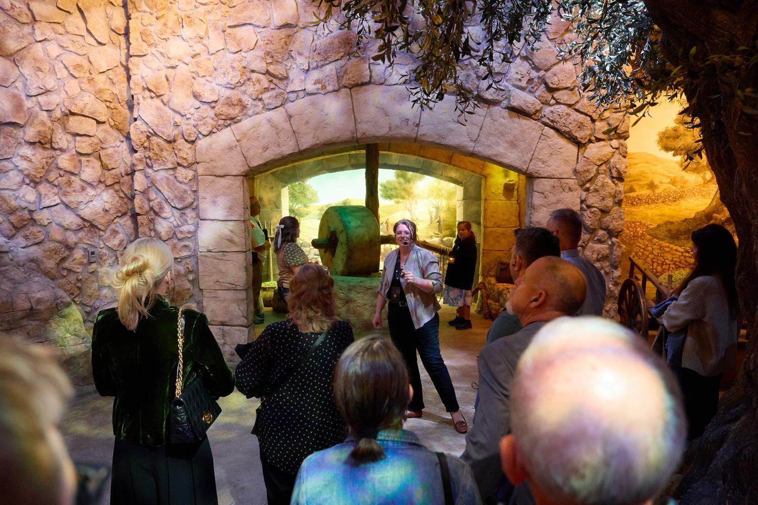 An Inspire guide leads guests through the reconstructed first-century Nazareth village during the Jesus of Nazareth tour at the Museum of the Bible.