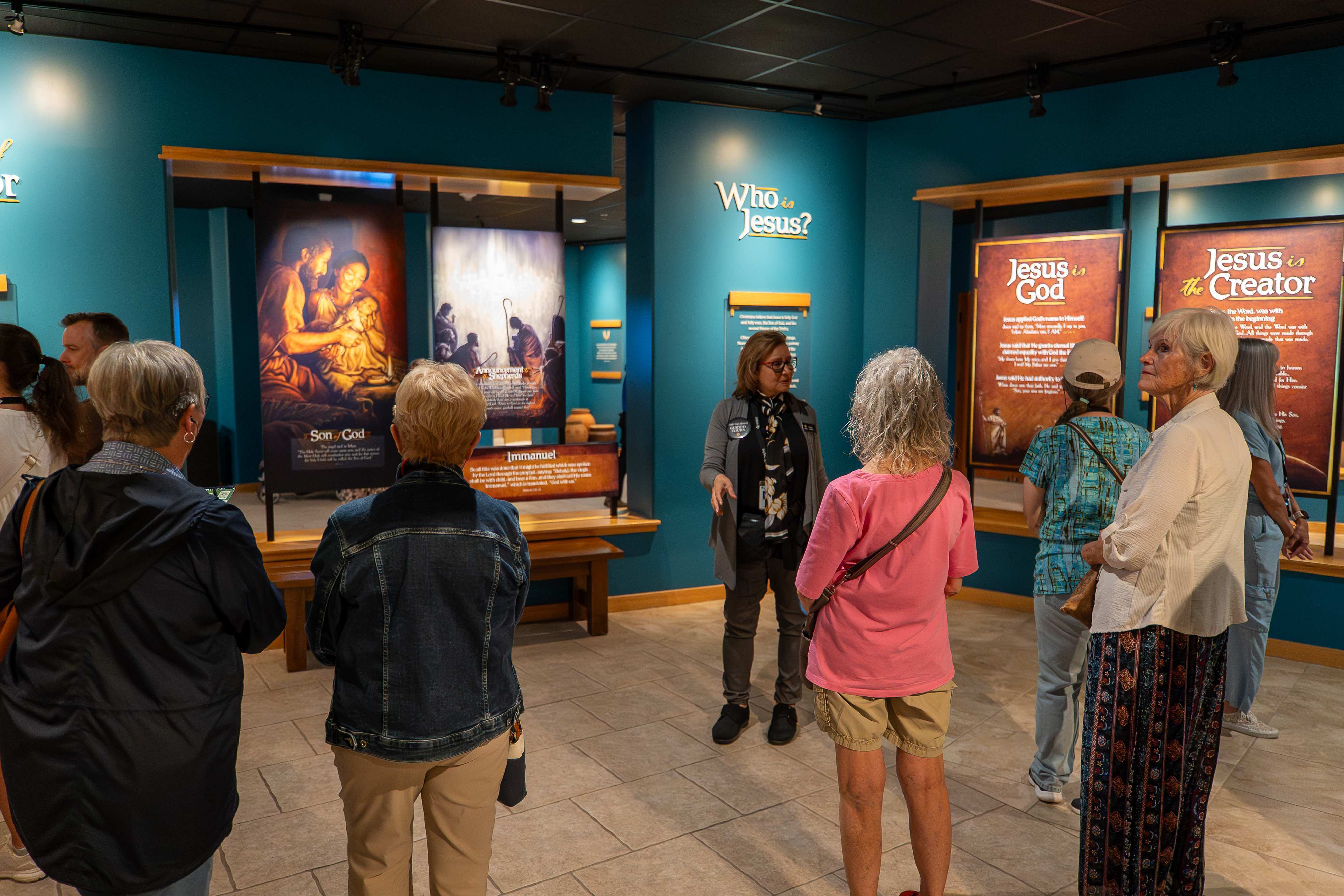 An Inspire guide explains the identity of Jesus during a guided tour through the Creation Museum's Who Is Jesus? exhibit, highlighting His deity and role as Creator.