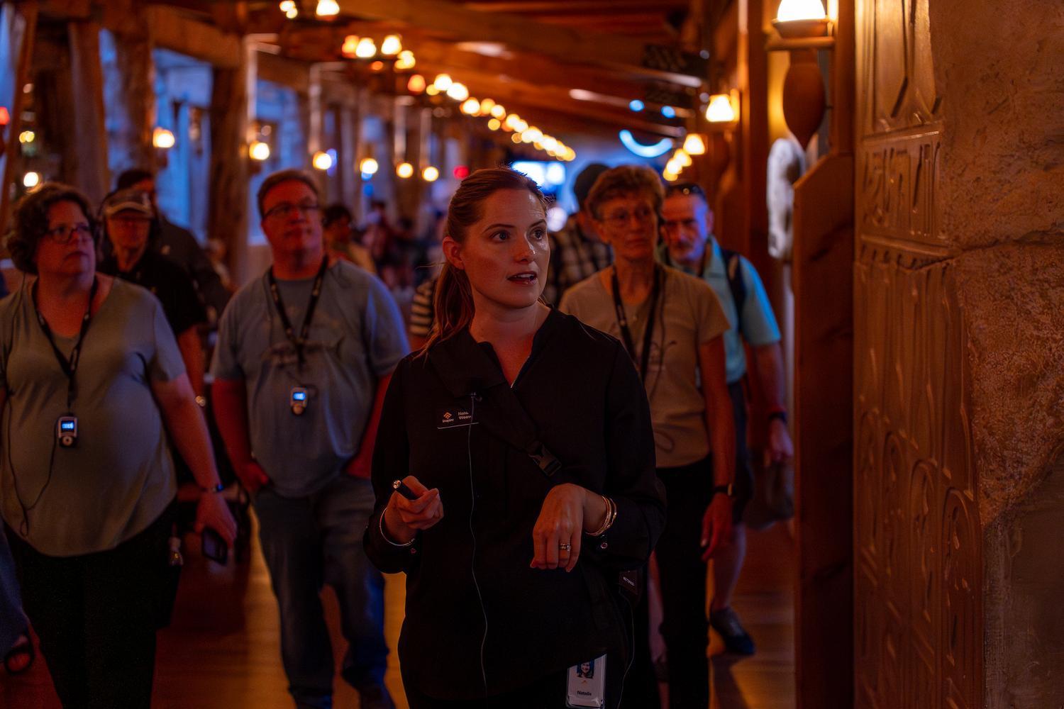 An Inspire guide leads guests through the interior of the Ark Encounter, explaining the exhibits as the group explores Noah's Ark together.