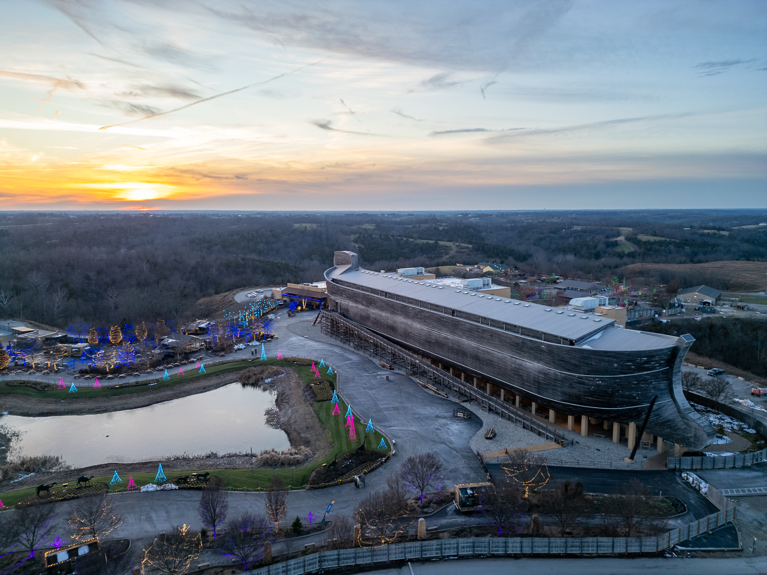 Aerial view of the life-size Noah's Ark at the Ark Encounter in Williamstown, Kentucky during sunset, overlooking the grounds and surrounding landscape around the Ark Encounter.