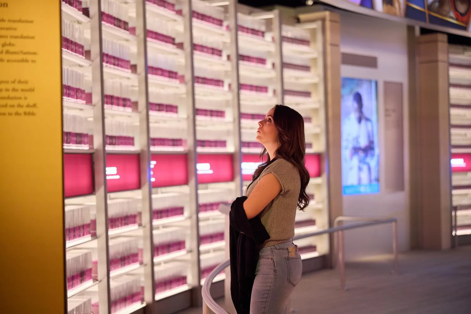A guest at Museum of the Bible looks on at IllumiNations, the room representing Bibles translated into different languages.