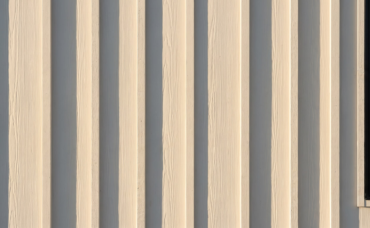 Close detail of fiber cement board and batten, showing the batten sitting proud of the board face.