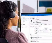 Woman with headphones viewing a computer screen showing a tech workflow interface.