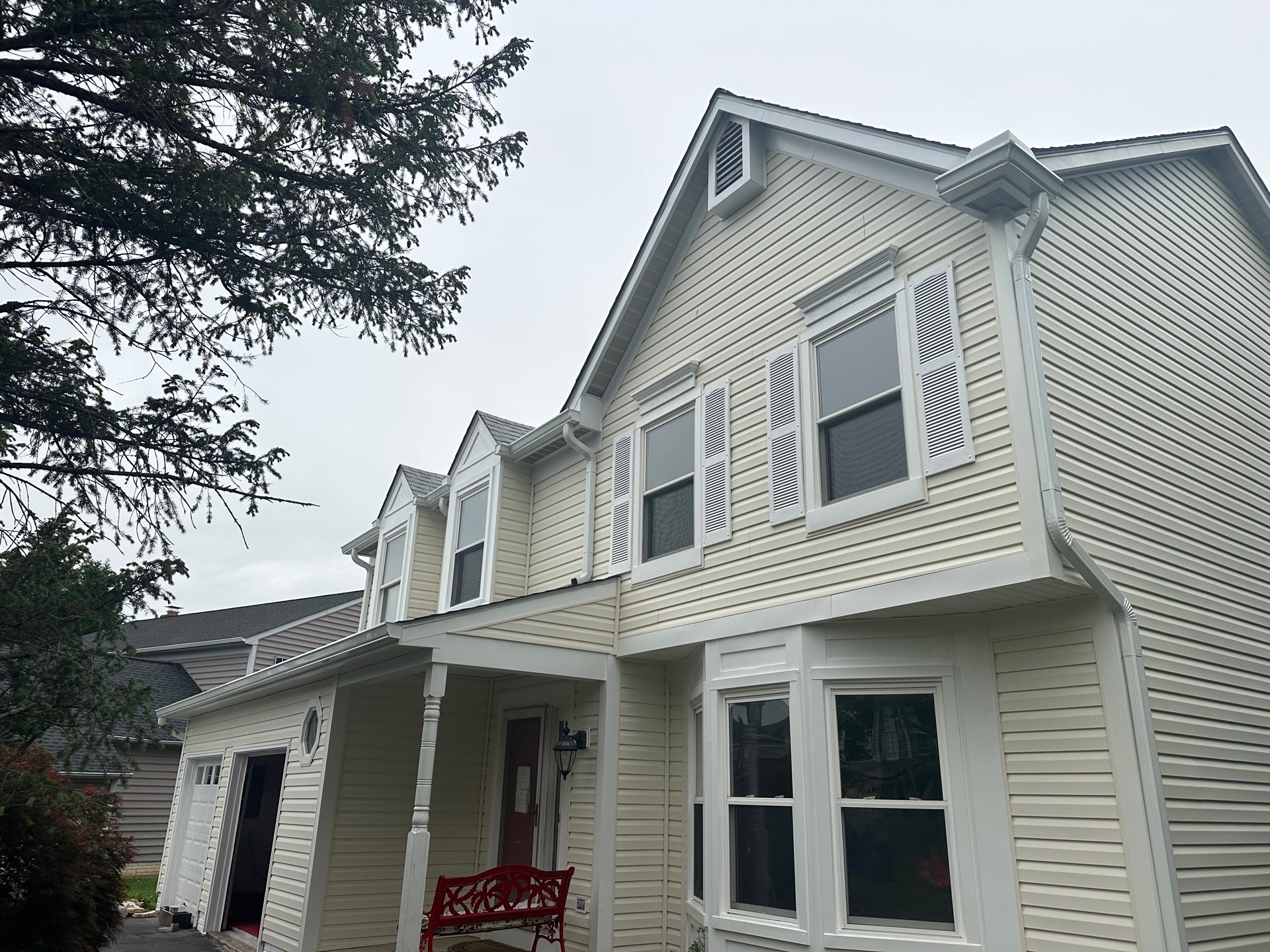 Completed exterior restoration with new siding, trim, gutters and downspouts