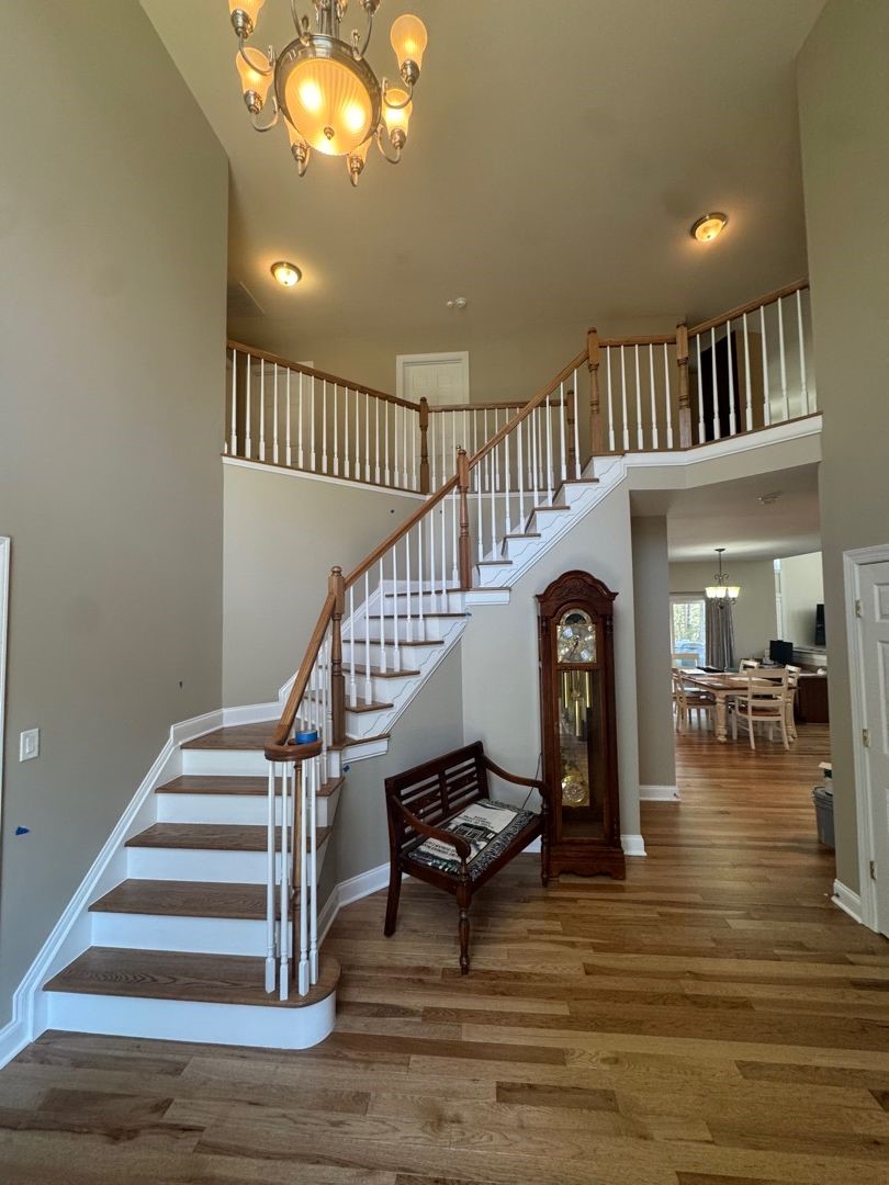 Restored two-story foyer with refinished hardwood floors and staircase