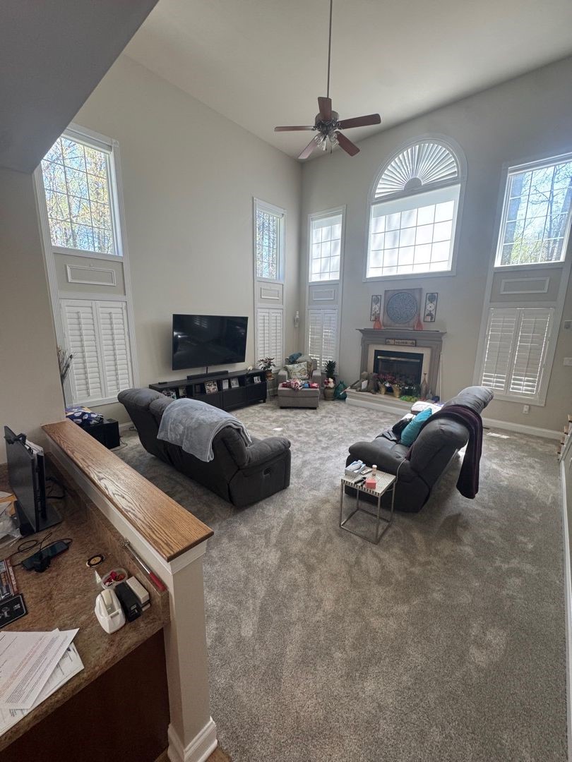 Completed two-story living room with new carpet and fresh paint after restoration