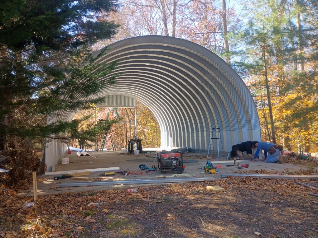 Arch steel building being erected on a prepared concrete slab
